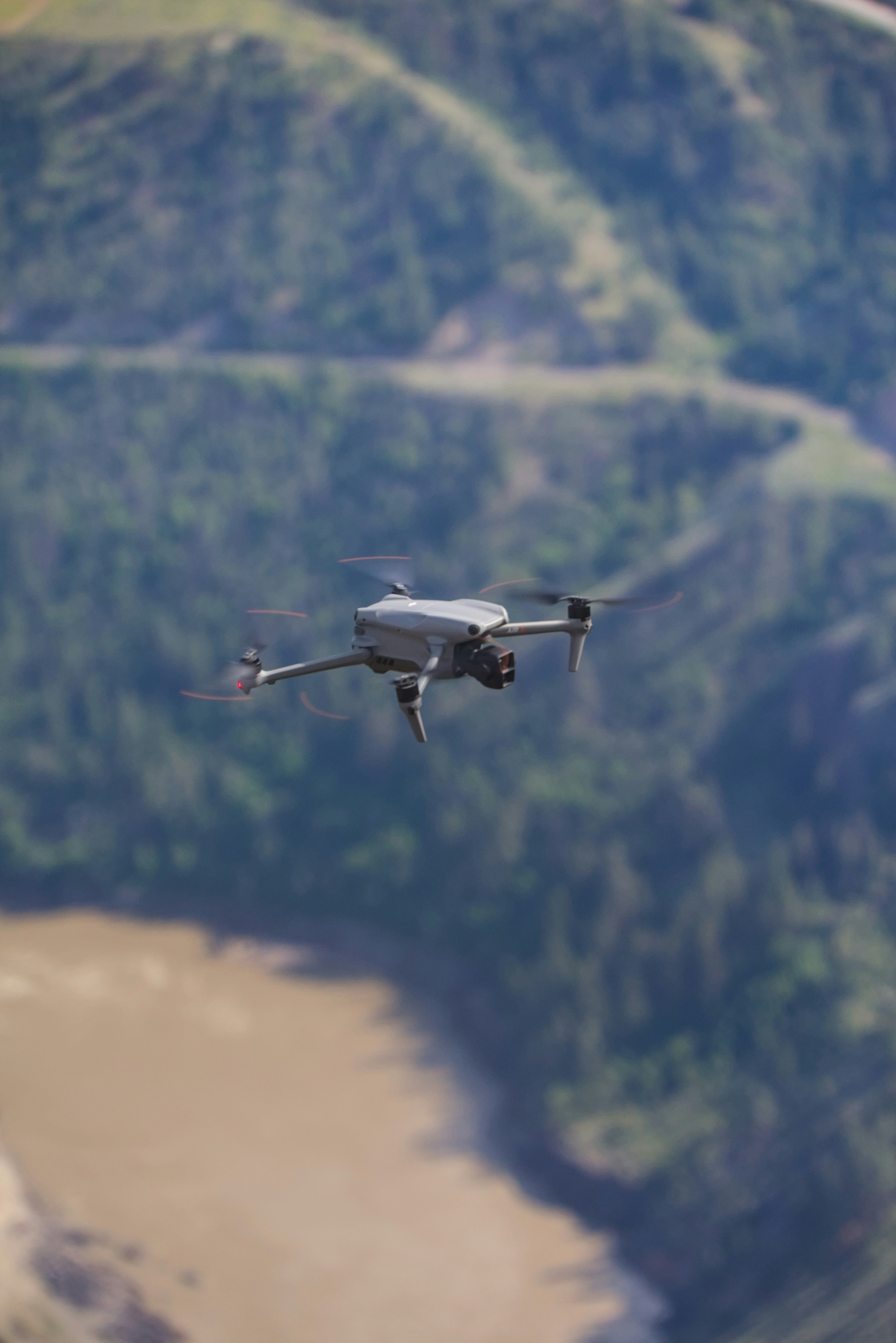 A drone flies over a scenic, natural landscape.