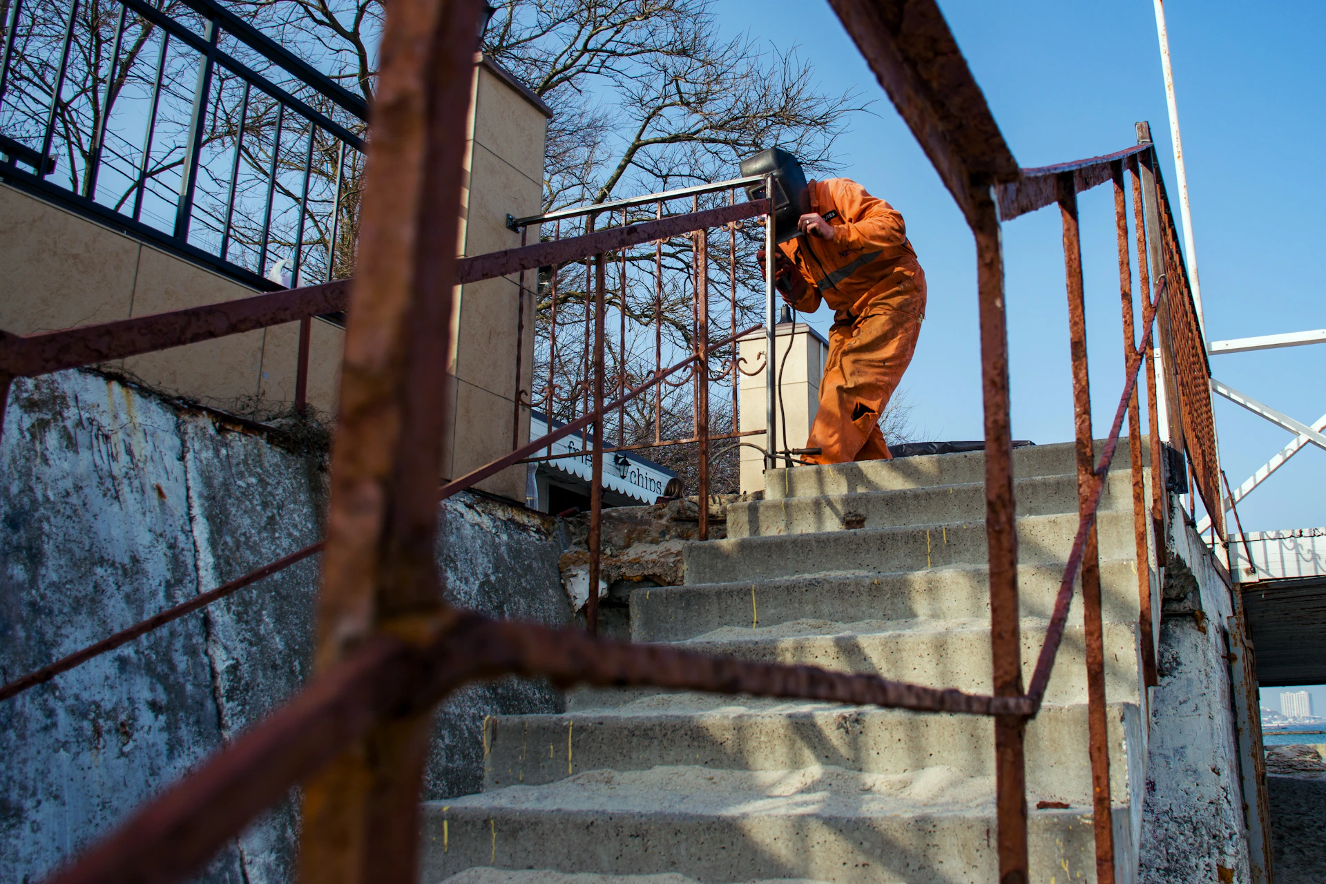 A person in an orange suit walks up stairs.