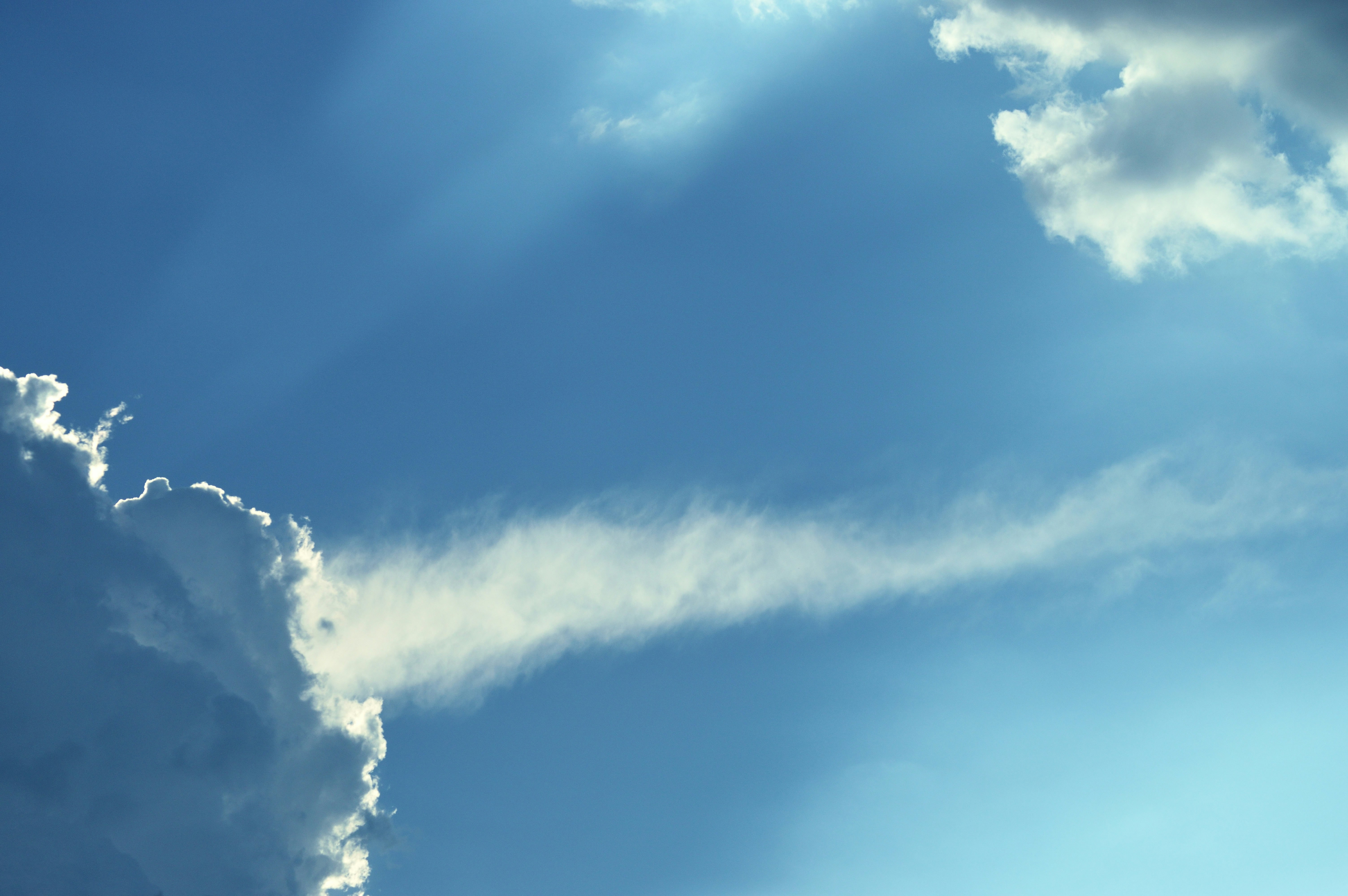 Bright clouds drift in the blue sky.