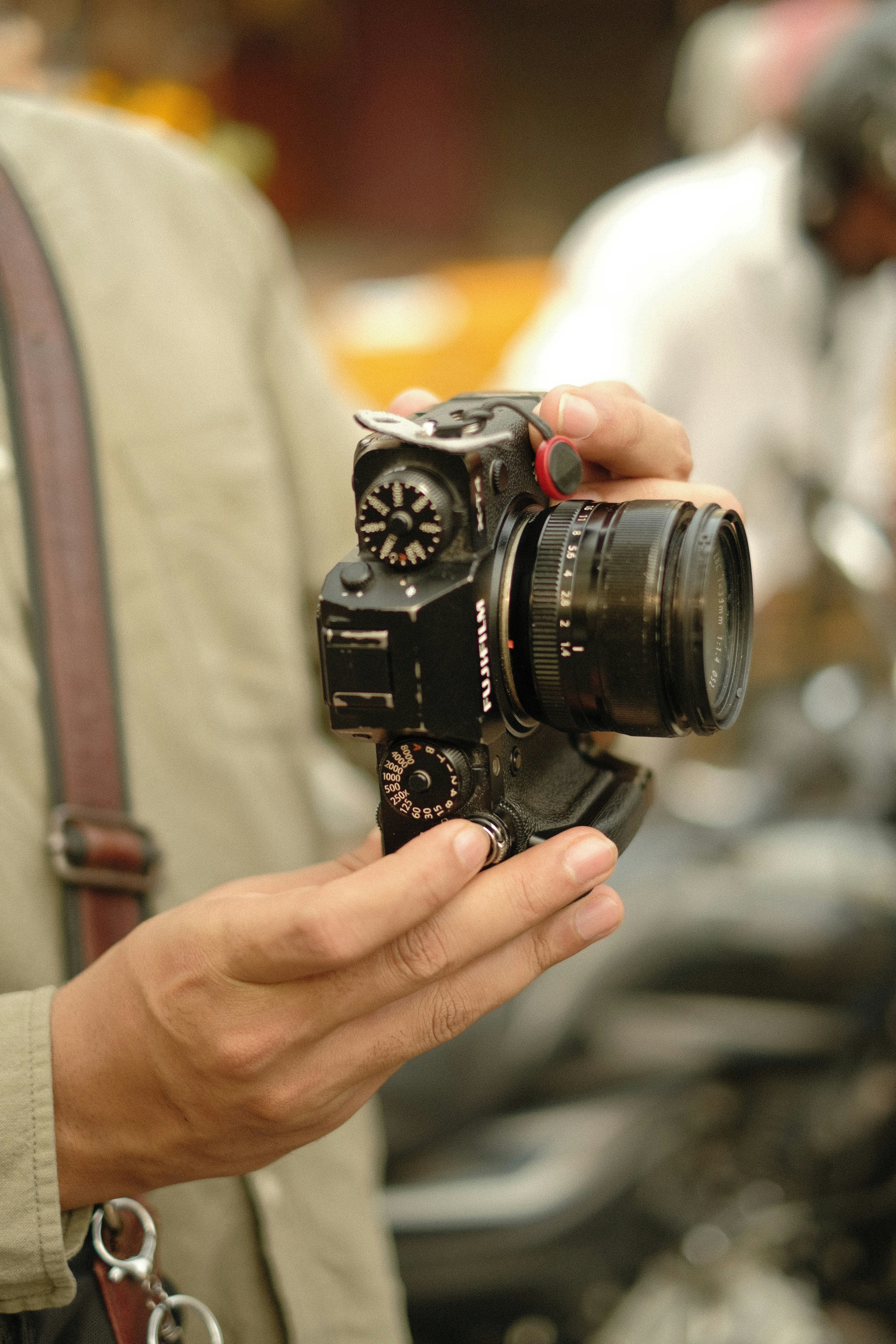 Ein Fotograf hält eine Fujifilm-Kamera in der Hand.