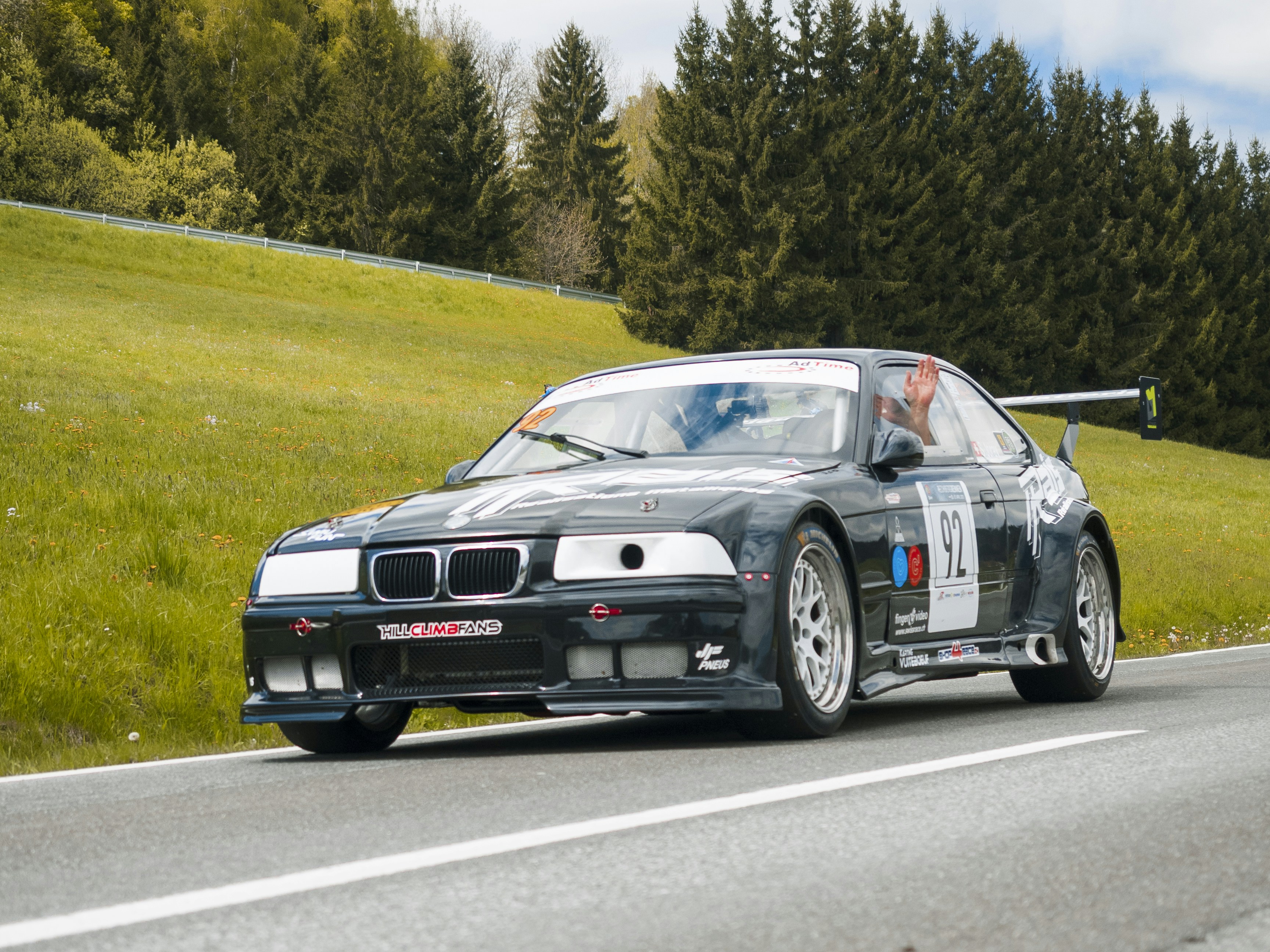 A BMW race car speeds down a road.
