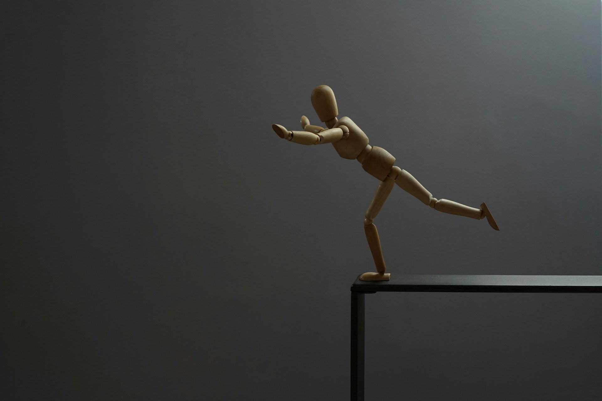 A wooden mannequin is about to fall.