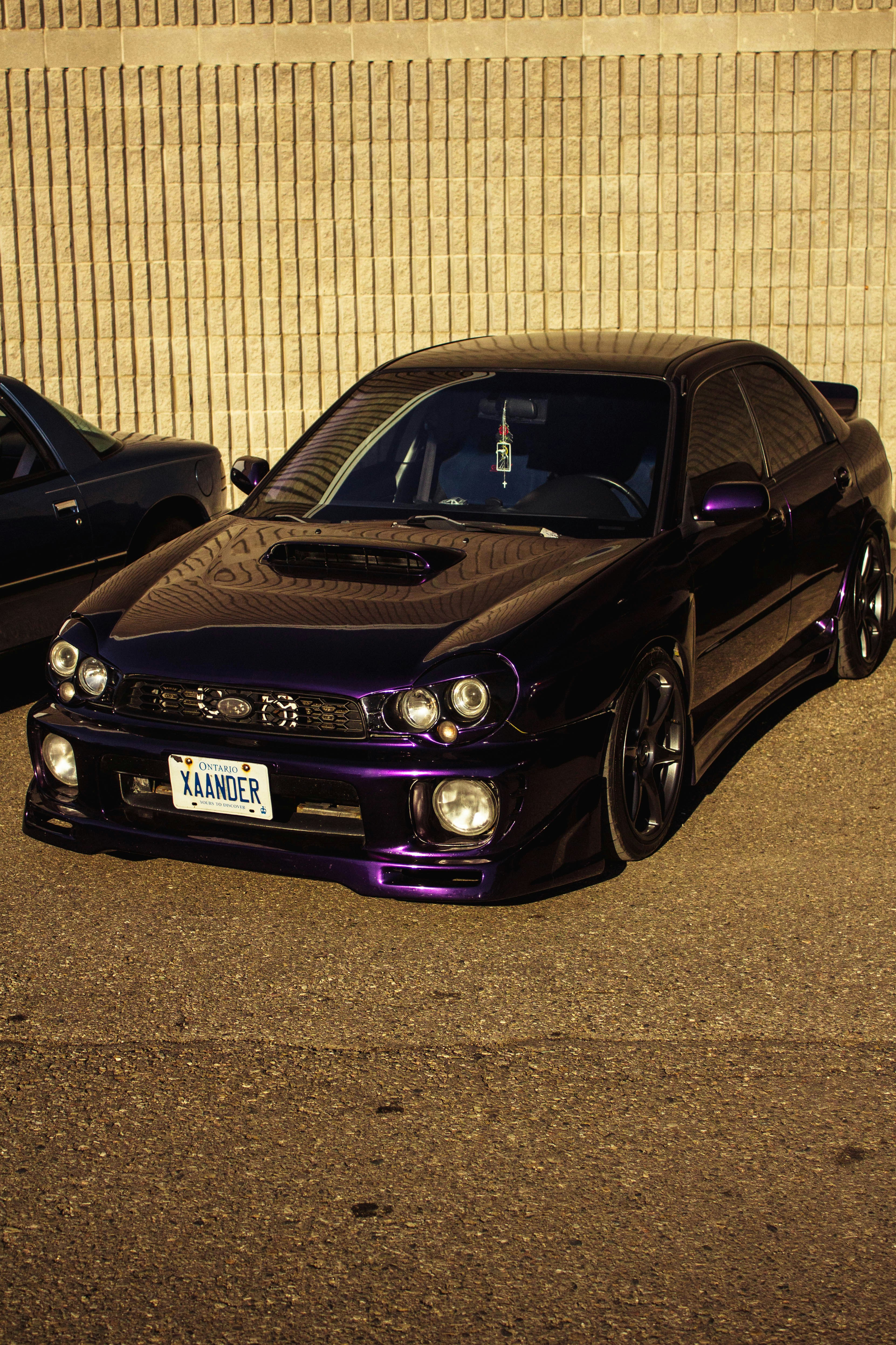A purple subaru impreza is parked outside.