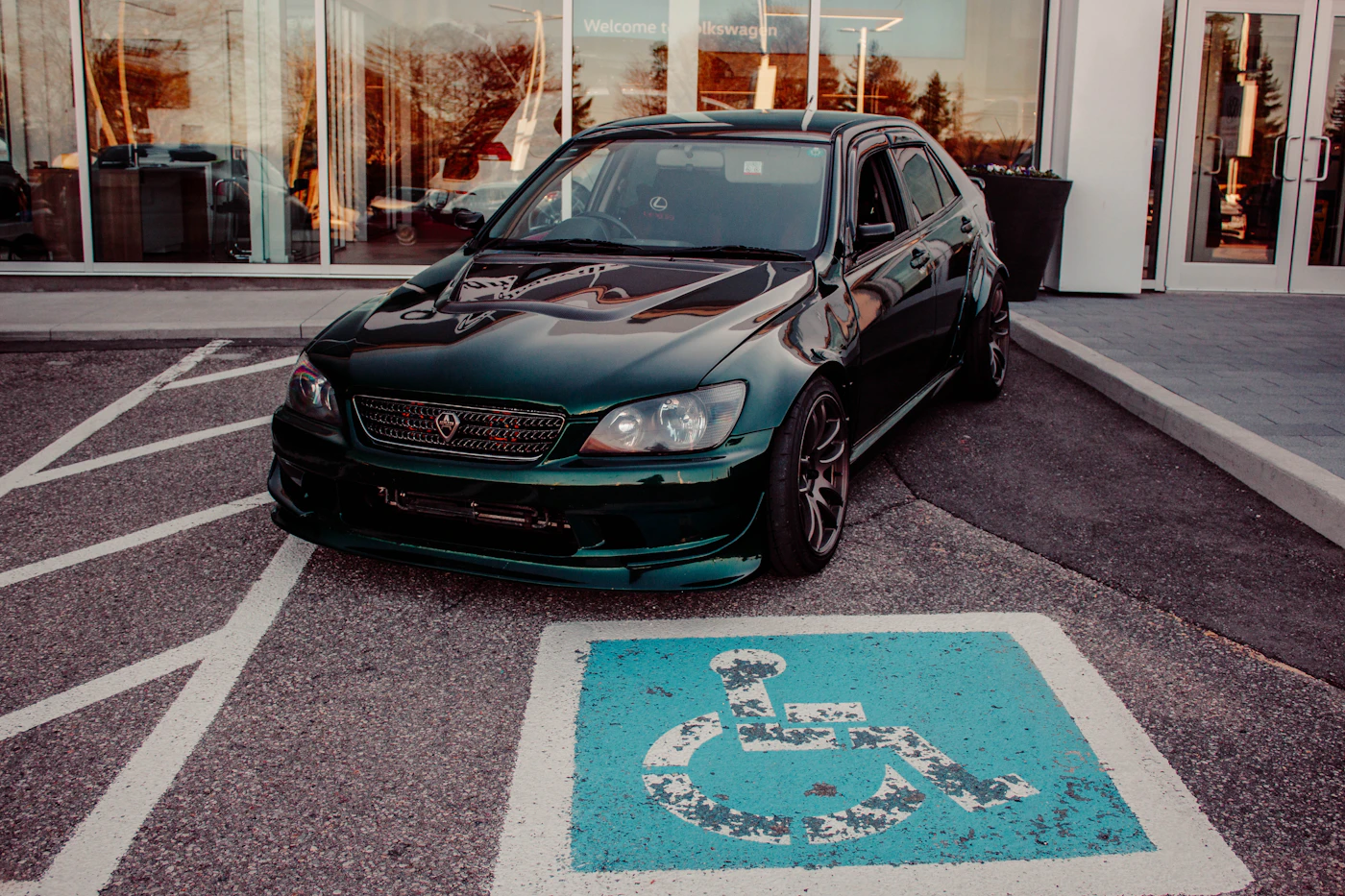 Dark green car parked in a marked space