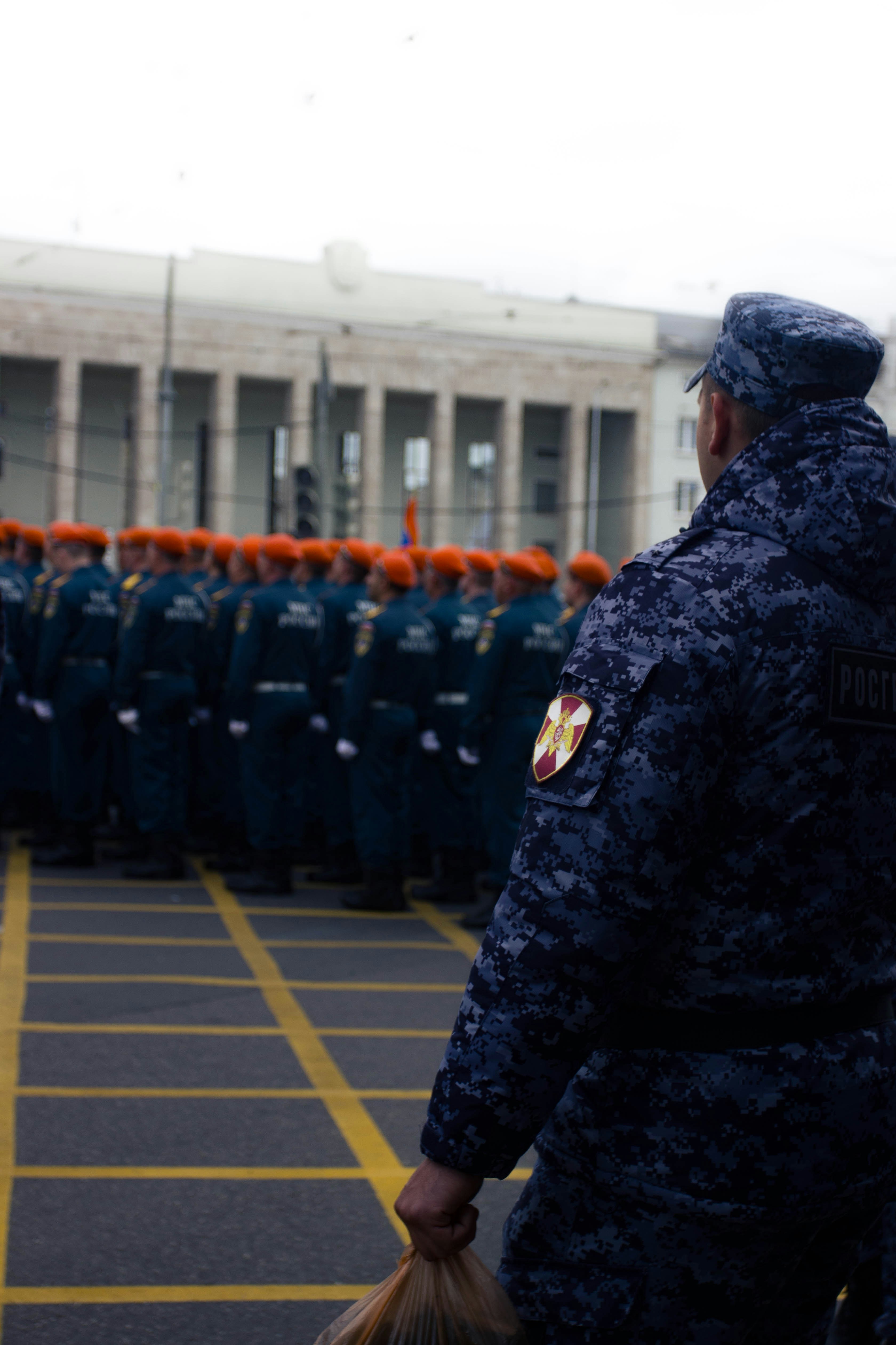 Soldiers stand in formation on a city street.