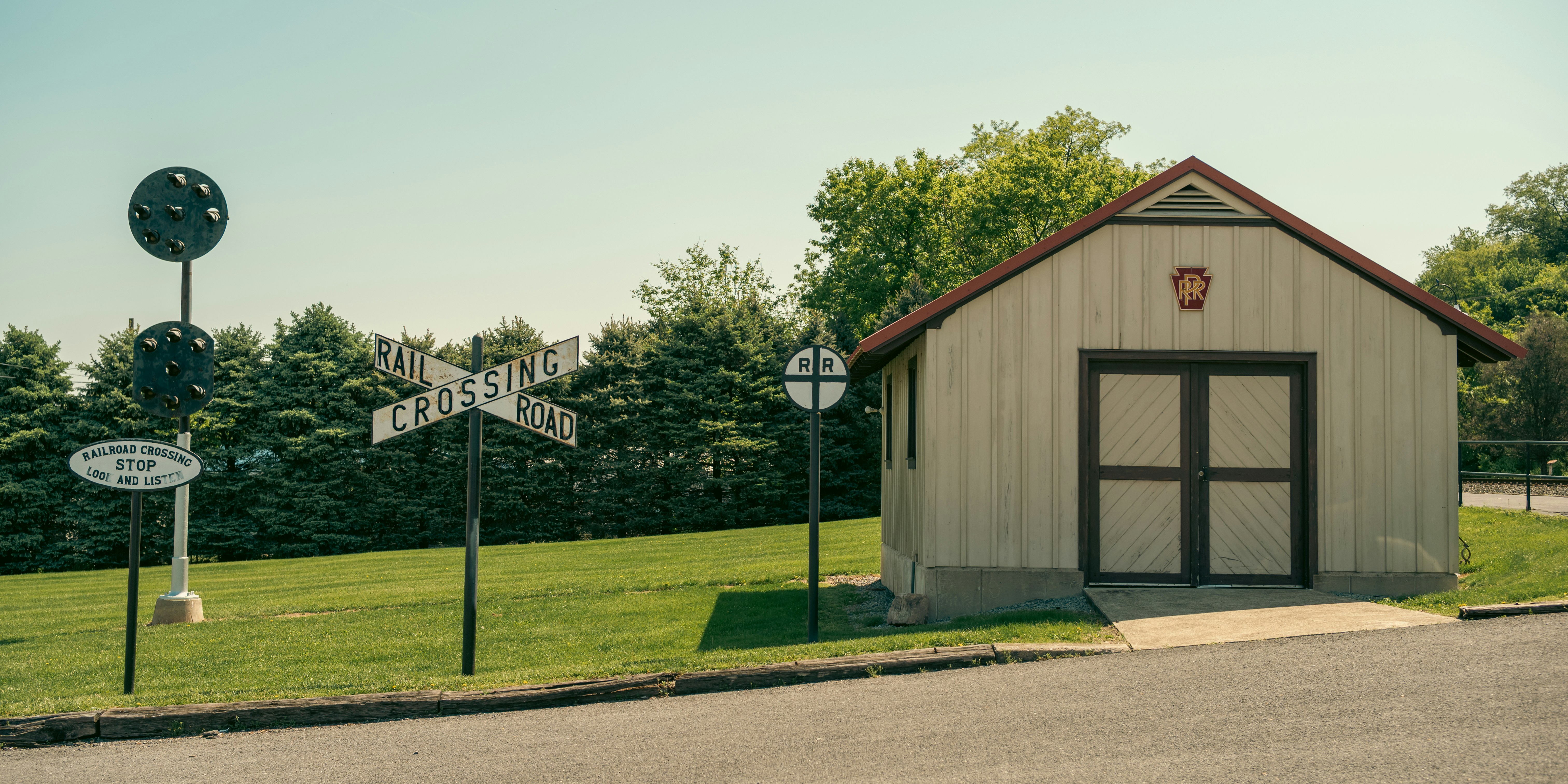A building next to railway signals and a lawn.
