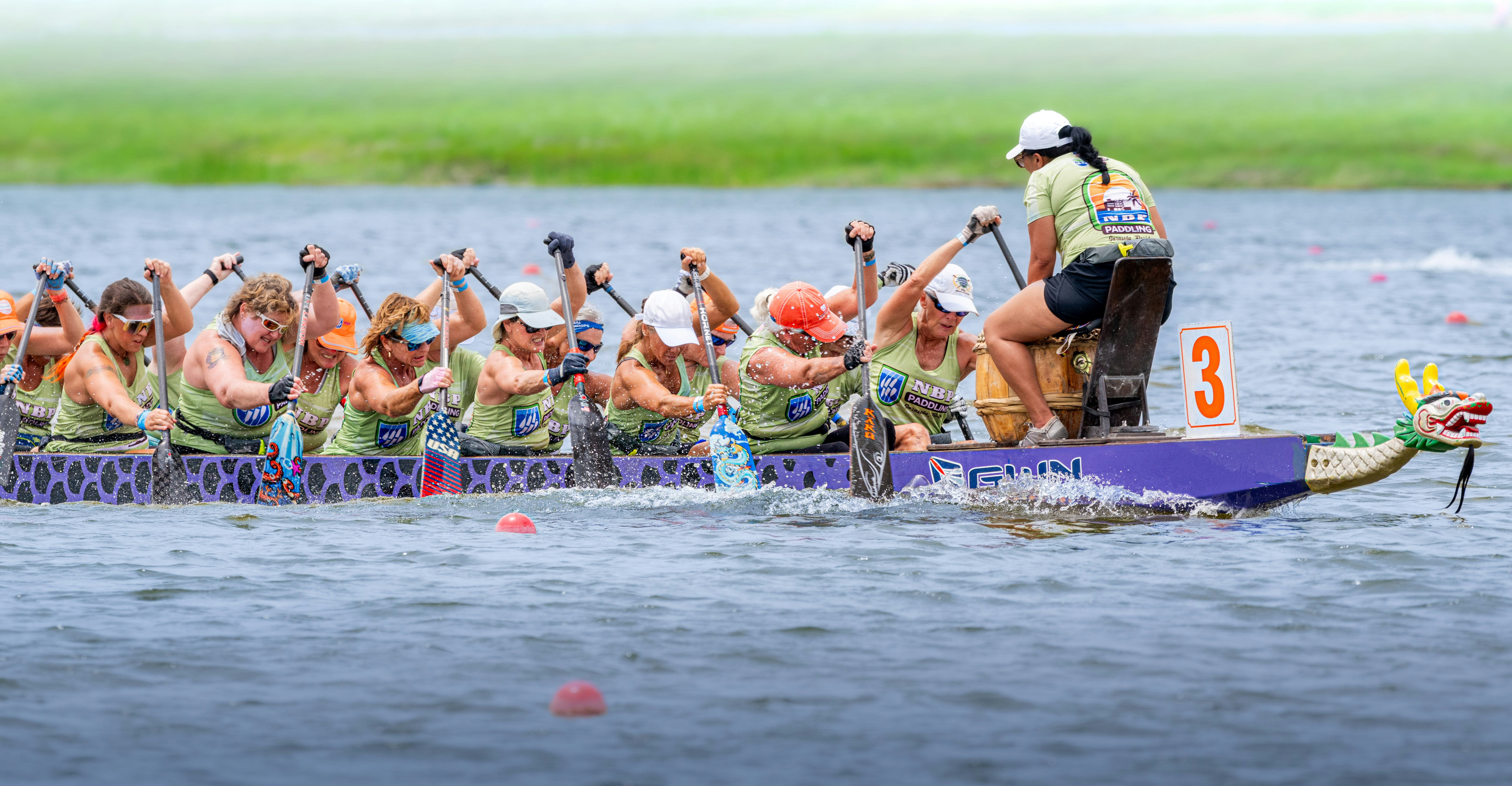 Kru perahu naga berlomba melintasi air.