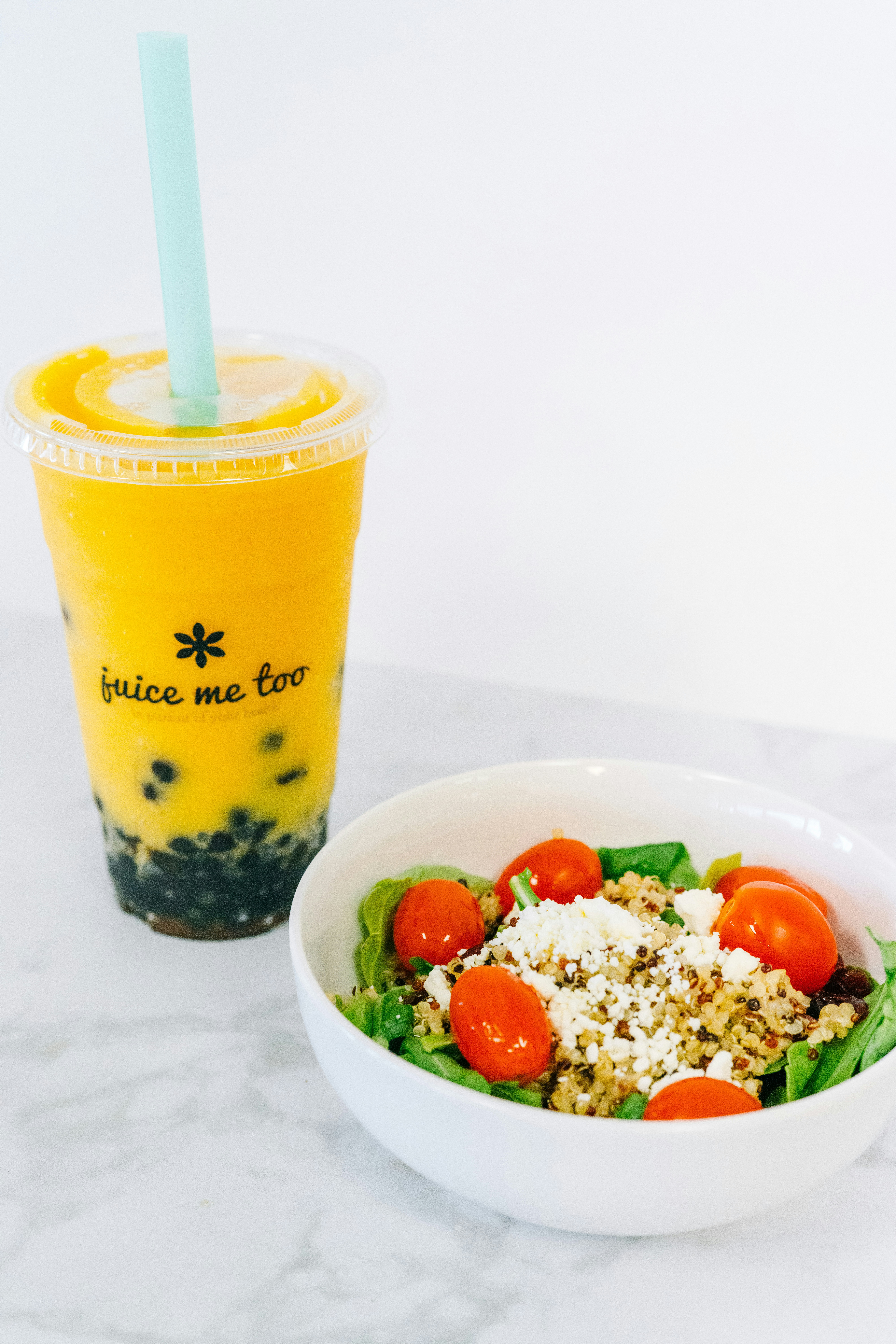 A boba drink and a salad are on display.