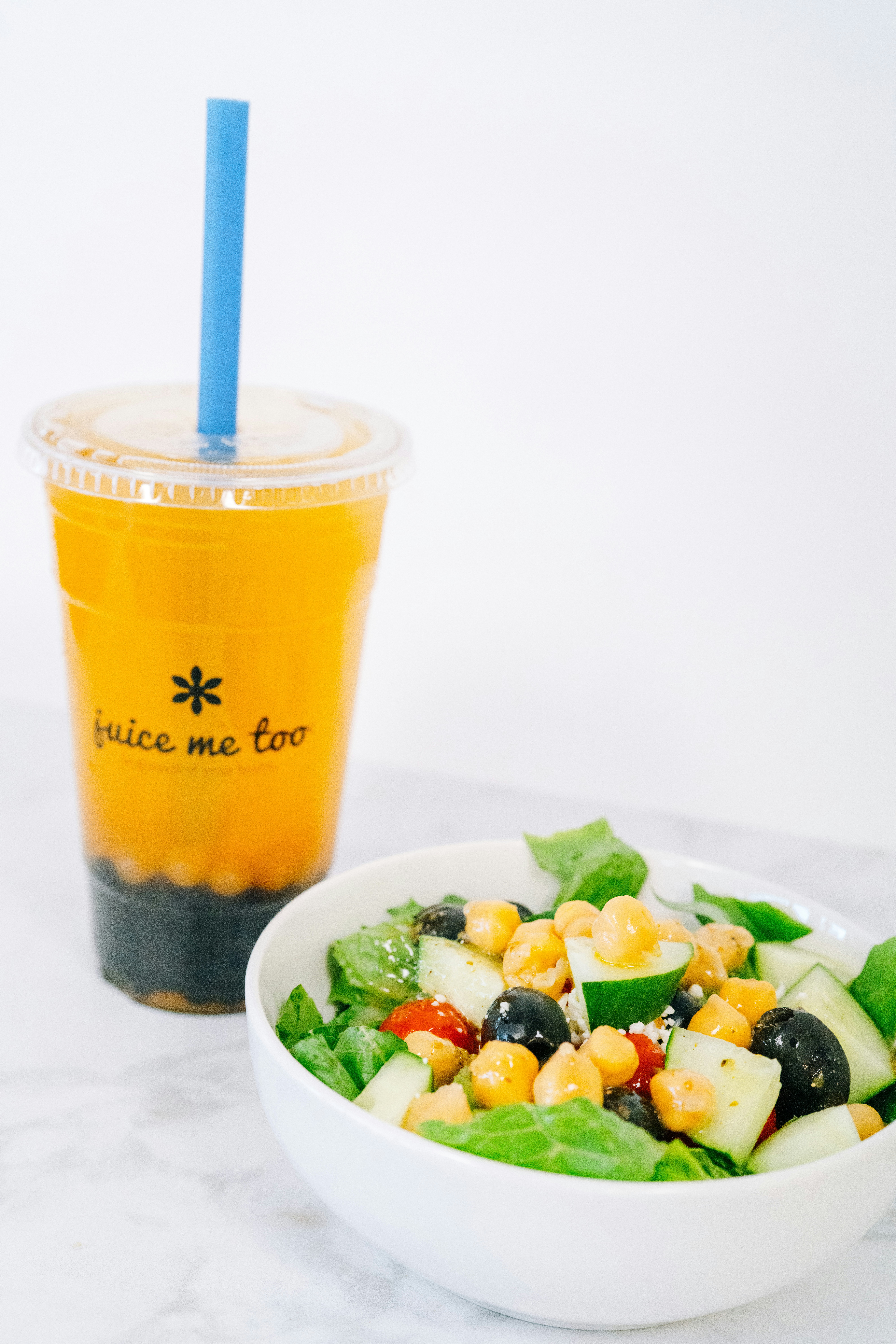 Orange juice and salad are ready for a meal.