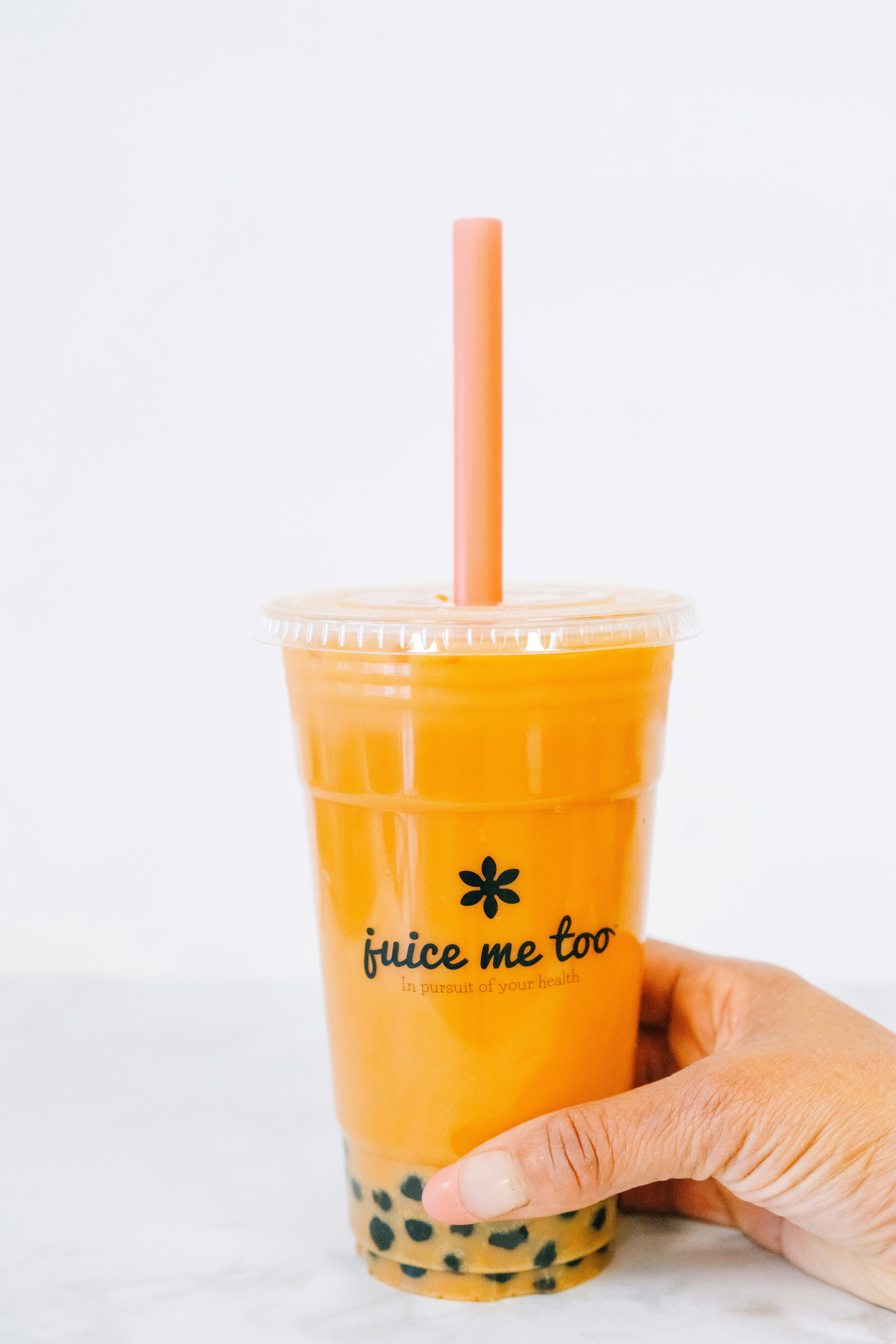 A hand holds a boba drink.