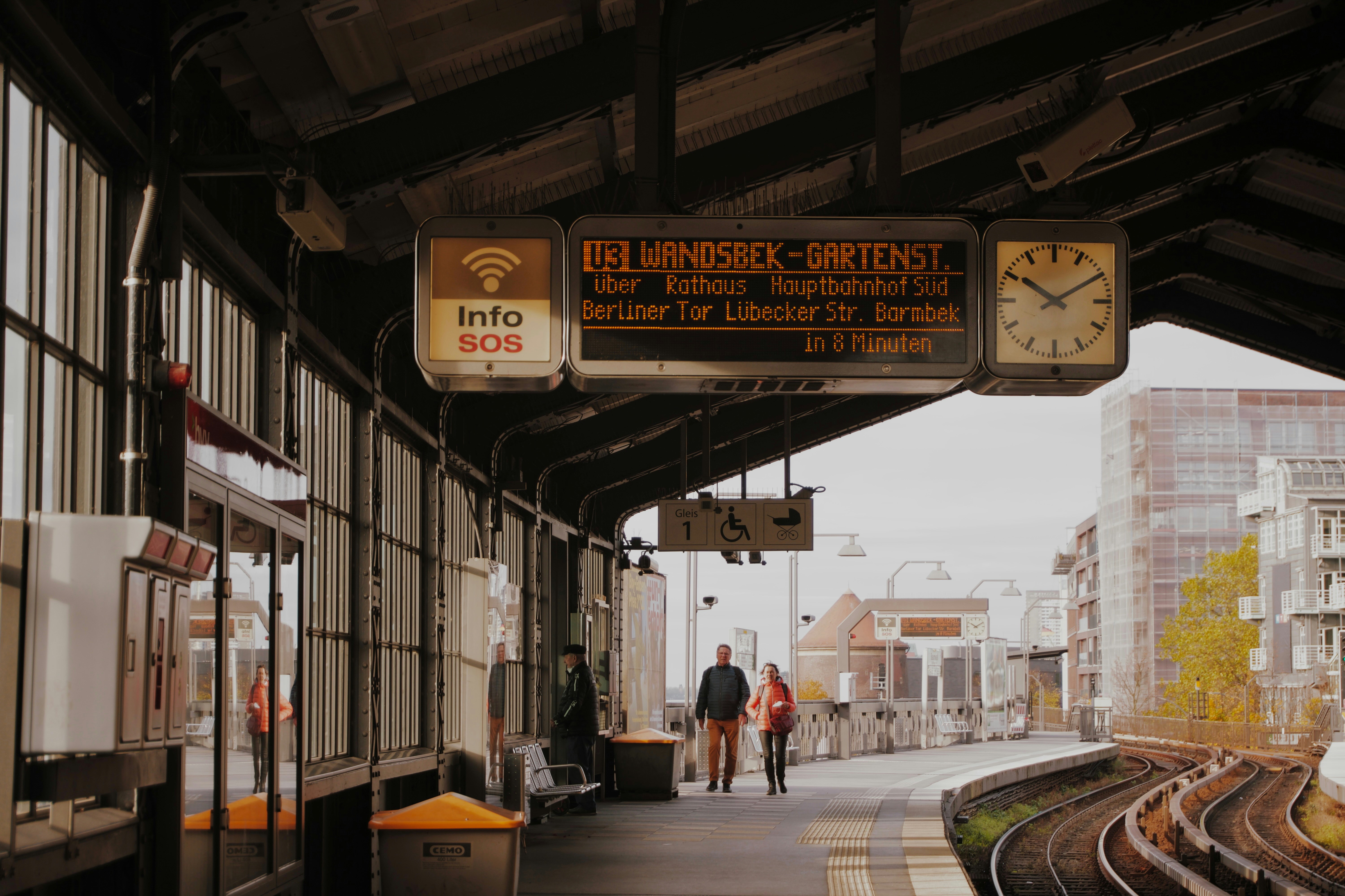 A train platform has a clock and information display.