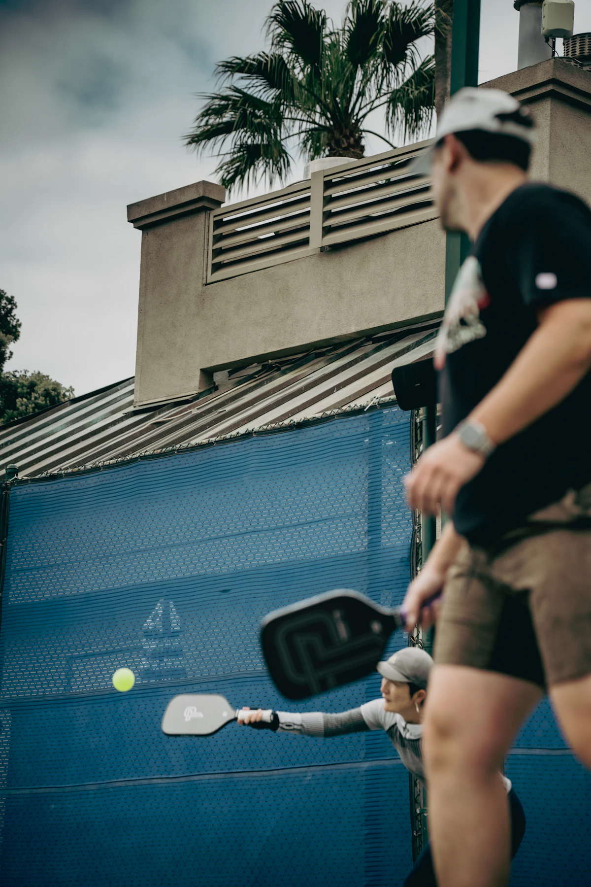 Players rallying with pickleball paddles on an outdoor court