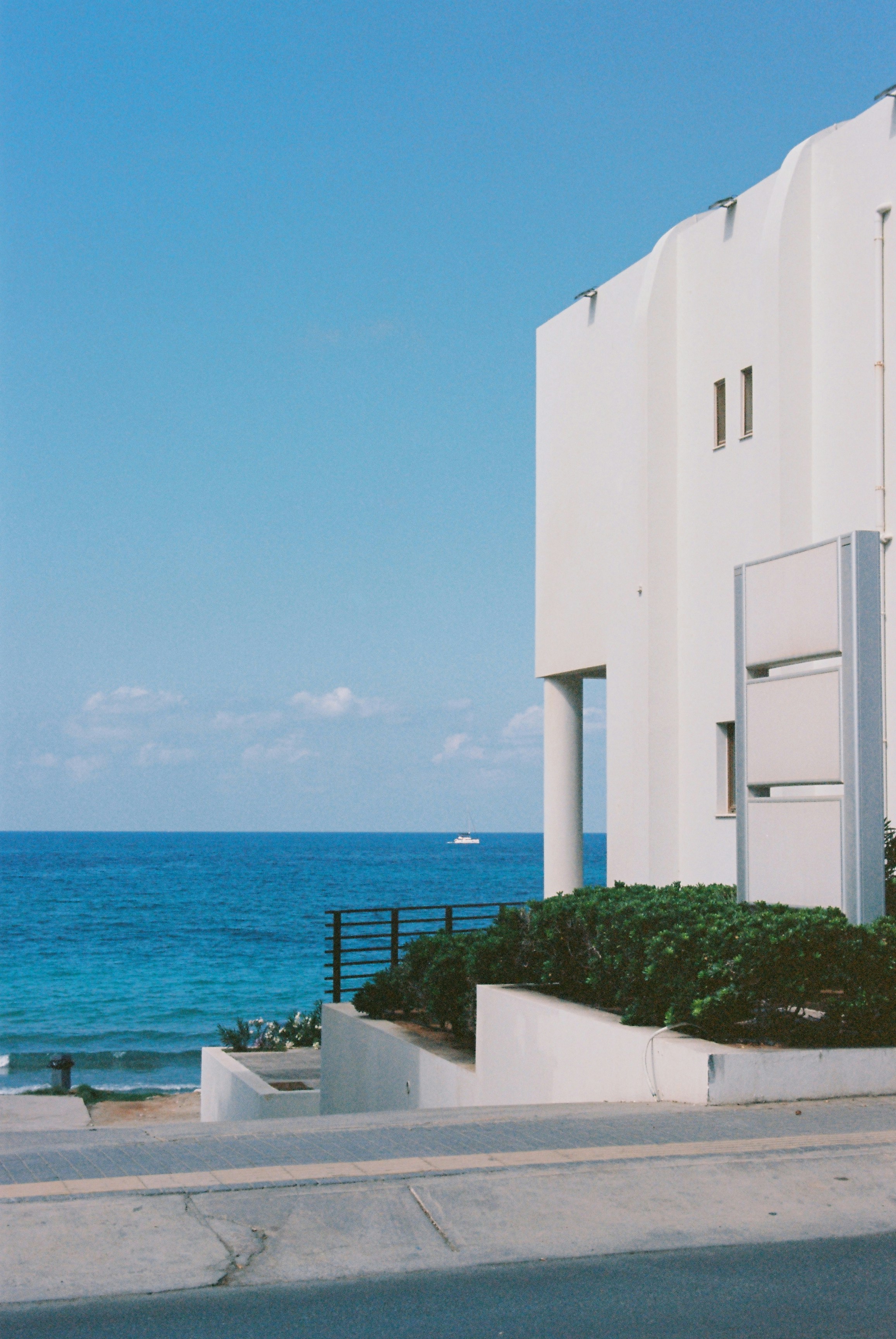 White building overlooks the ocean on a sunny day.