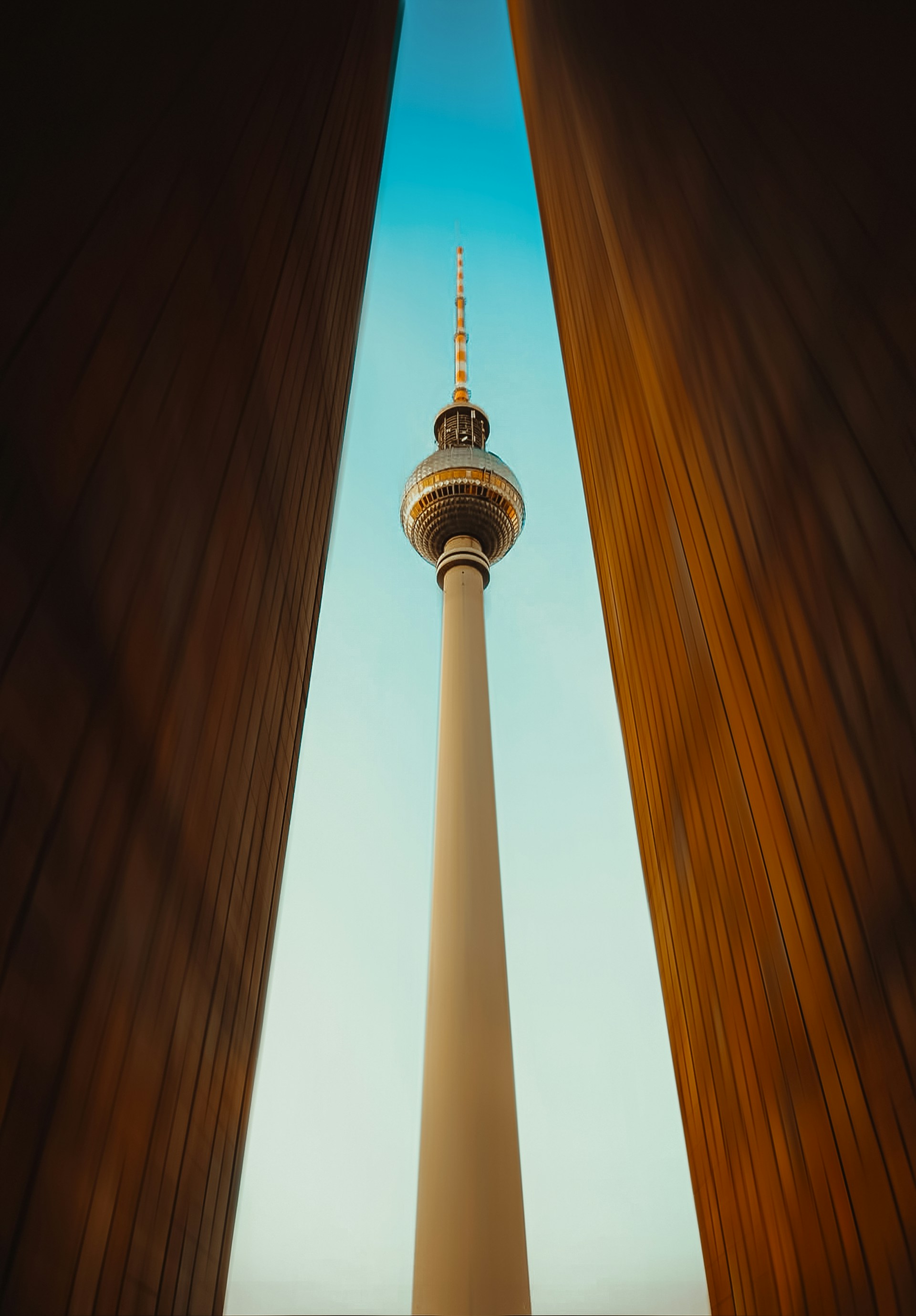 The berlin TV tower is framed between two structures.