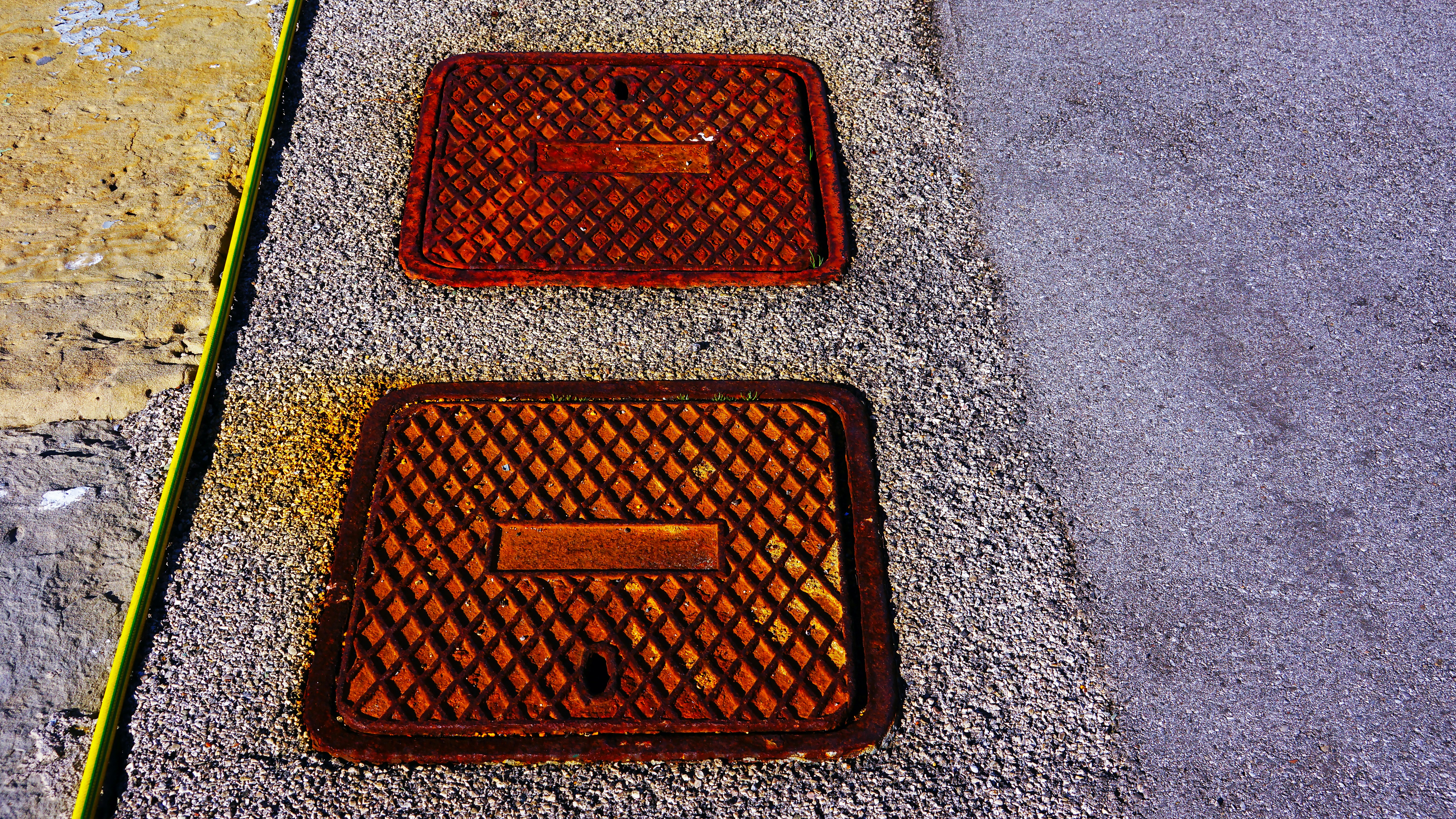 Two rusty rectangular metal covers.