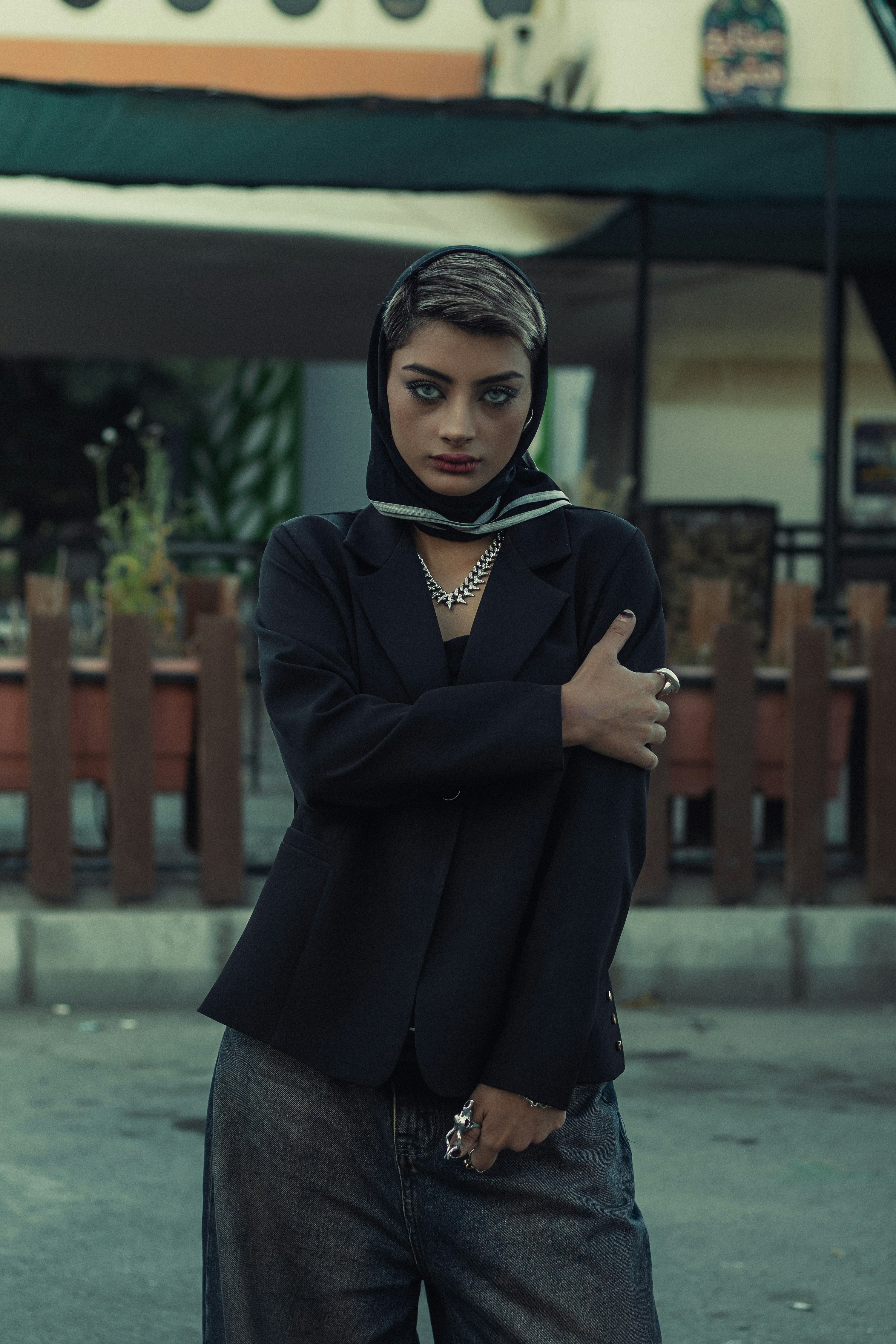 A woman poses confidently in fashionable clothing.