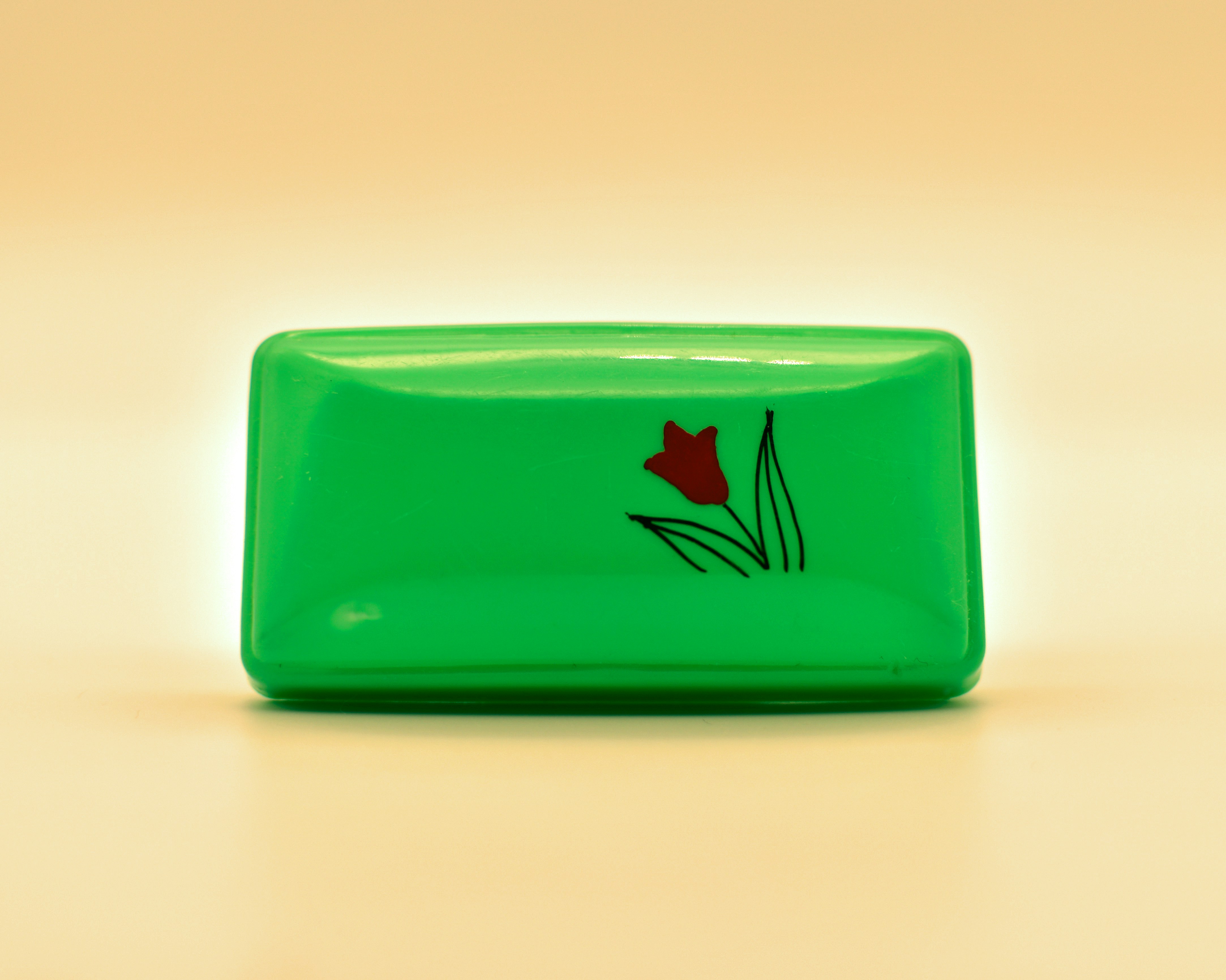Una caja verde adornada con una flor.