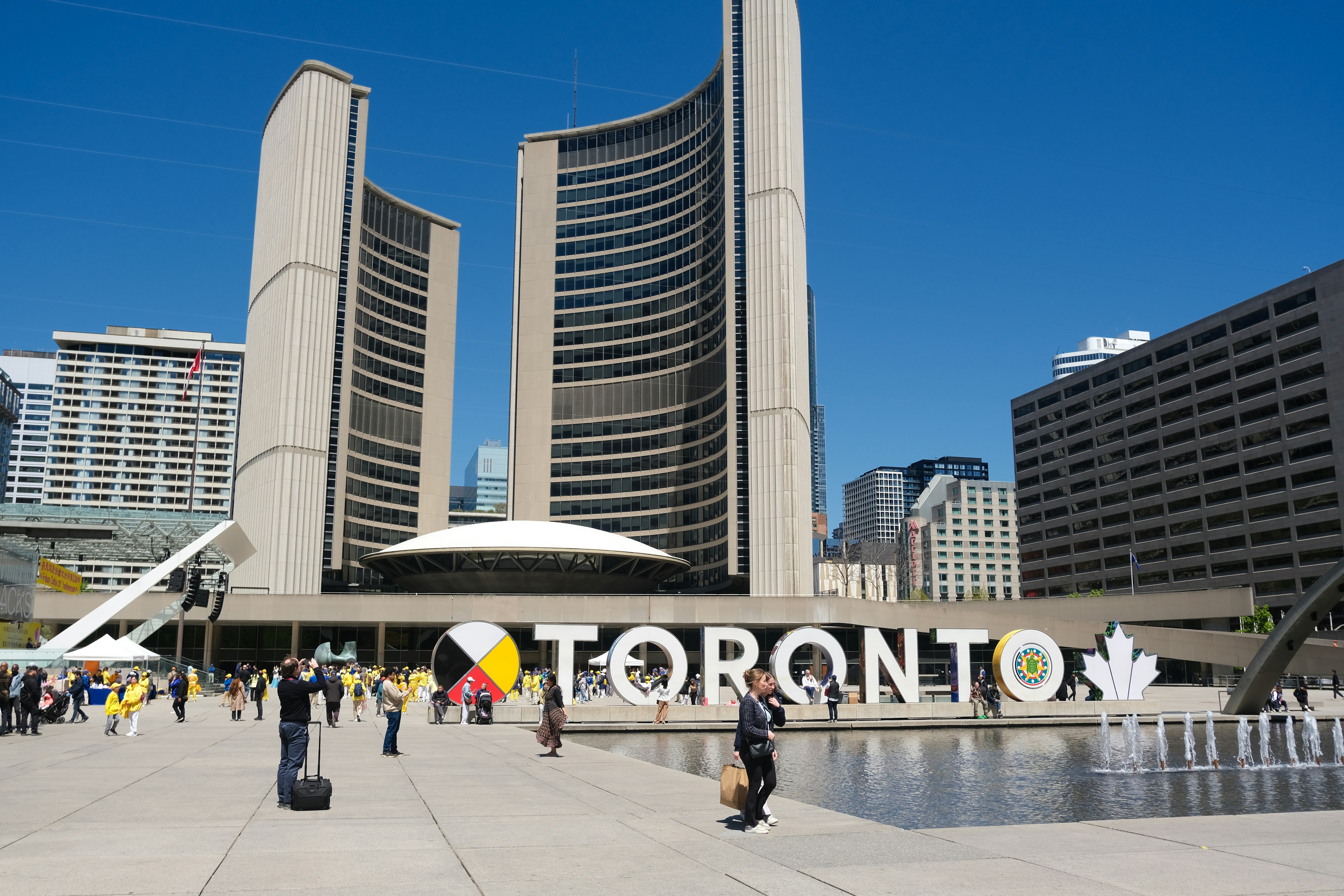 Toronto city hall and sign visible from a construction site, illustrating Ontario spring permit regulations for a baseme