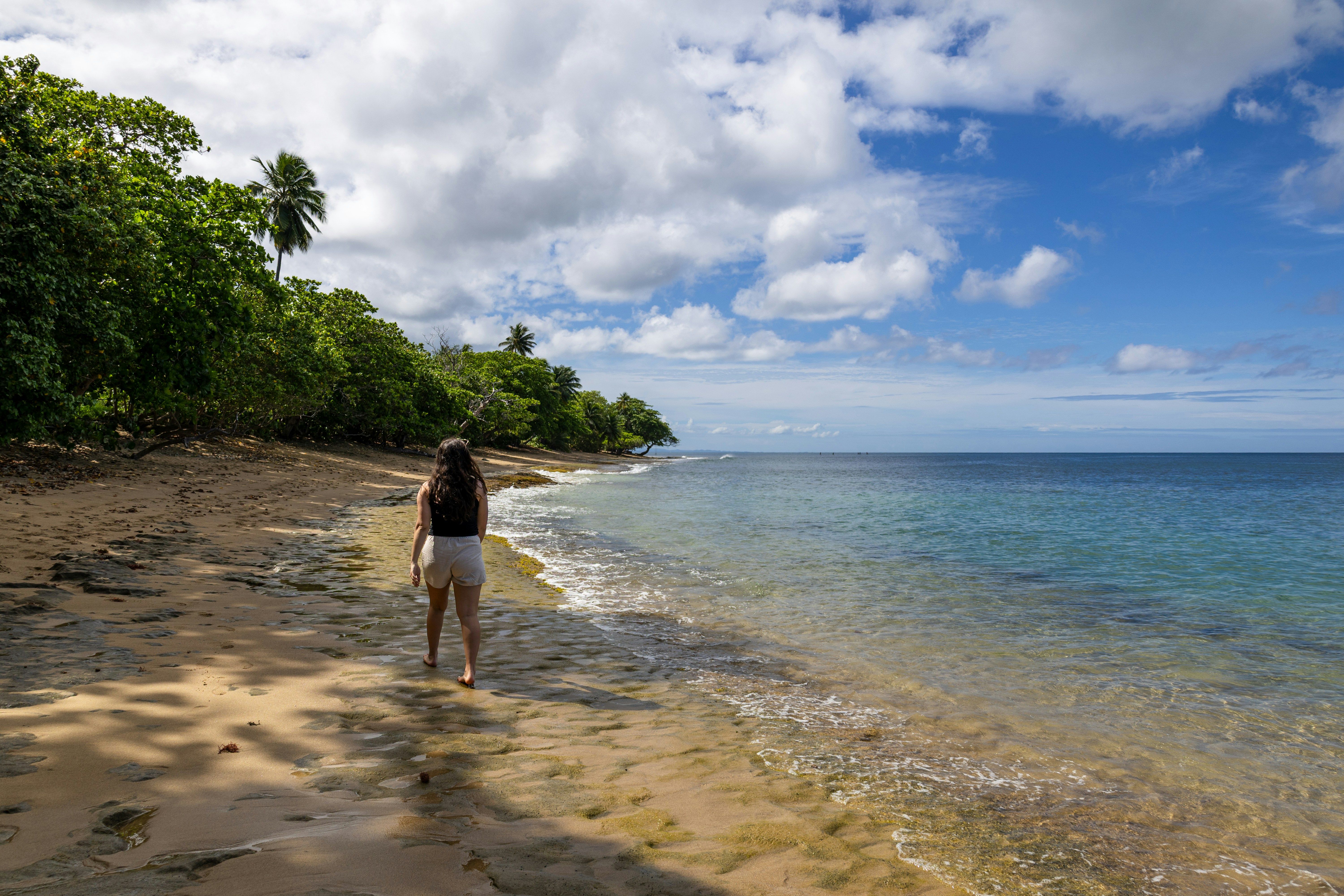 A person walks along a beautiful beach.