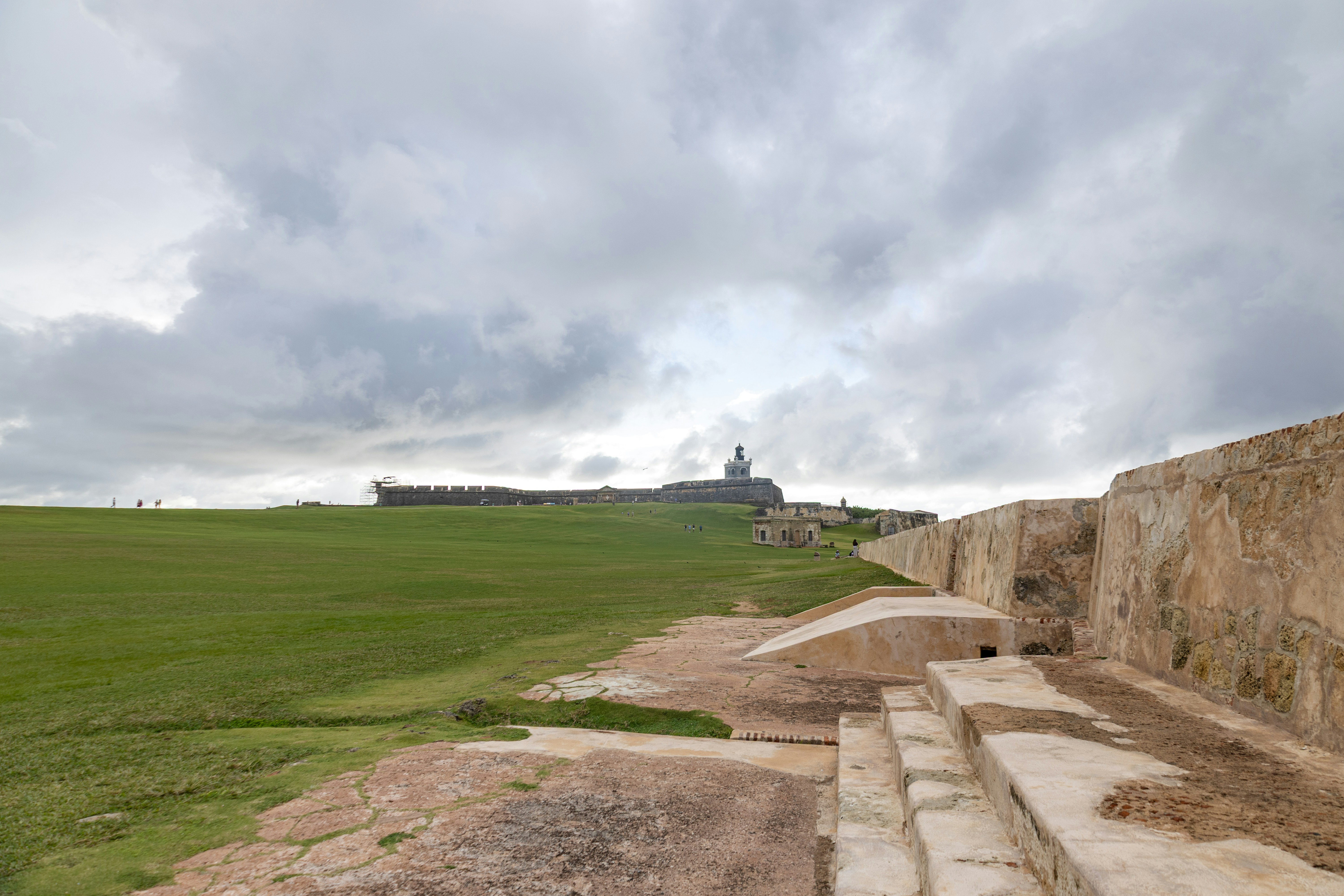 A cloudy day shows fortified walls and greenery.