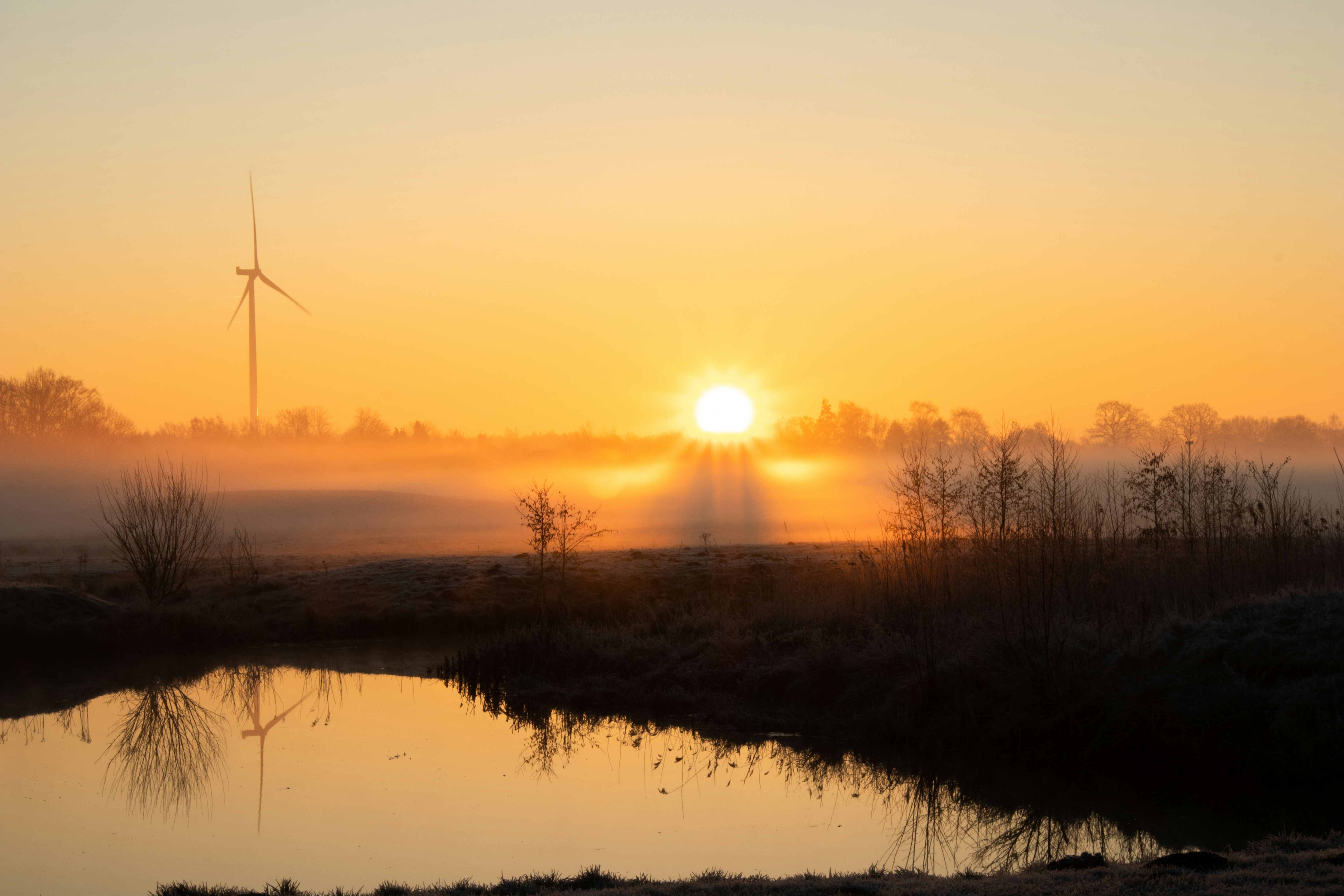 Sunrise shines brightly over a misty landscape.