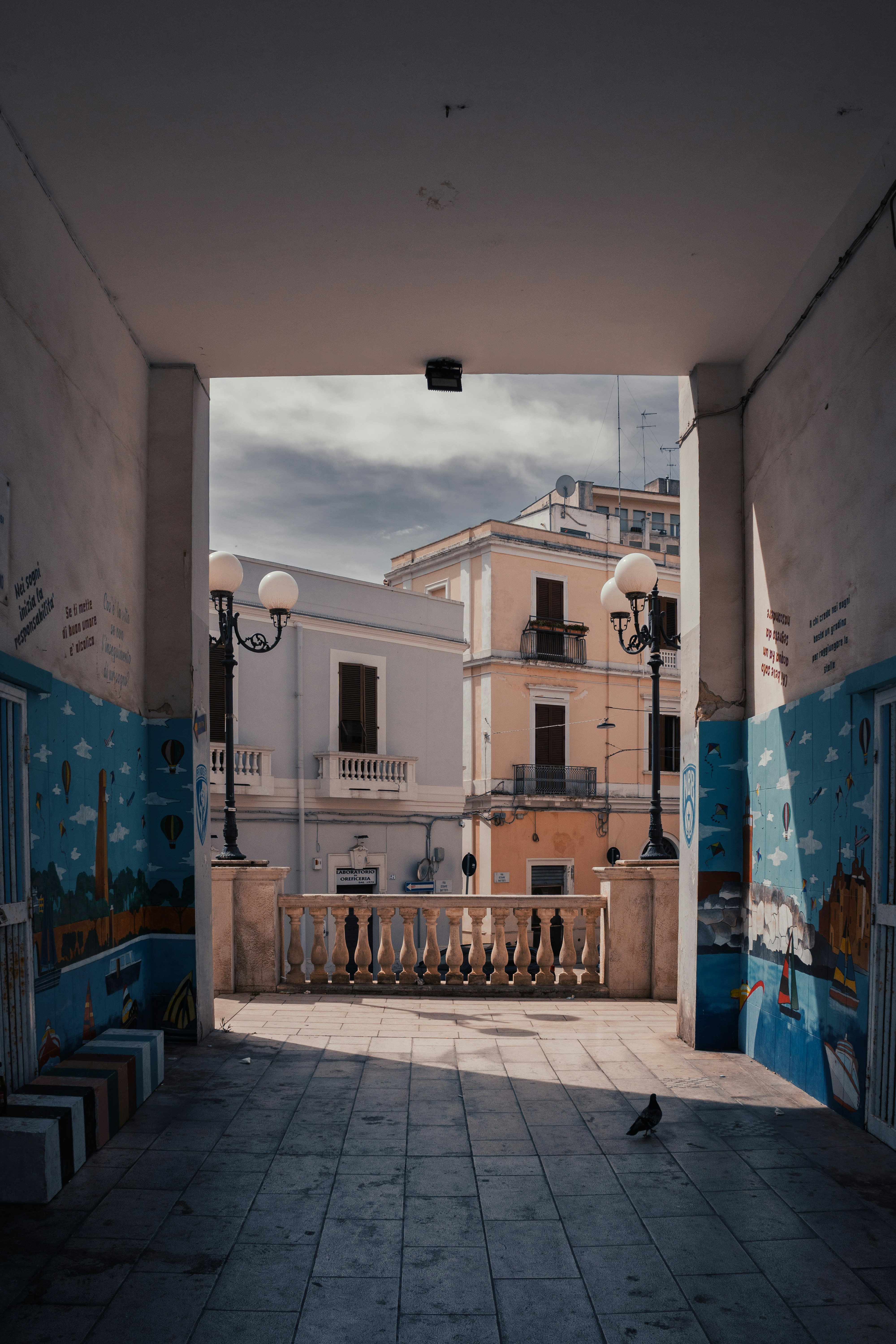 A sunny cityscape is seen through an archway.
