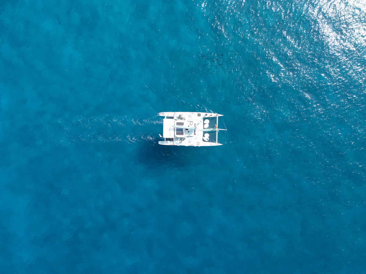 Yacht blanc naviguant sur un océan tropical bleu
