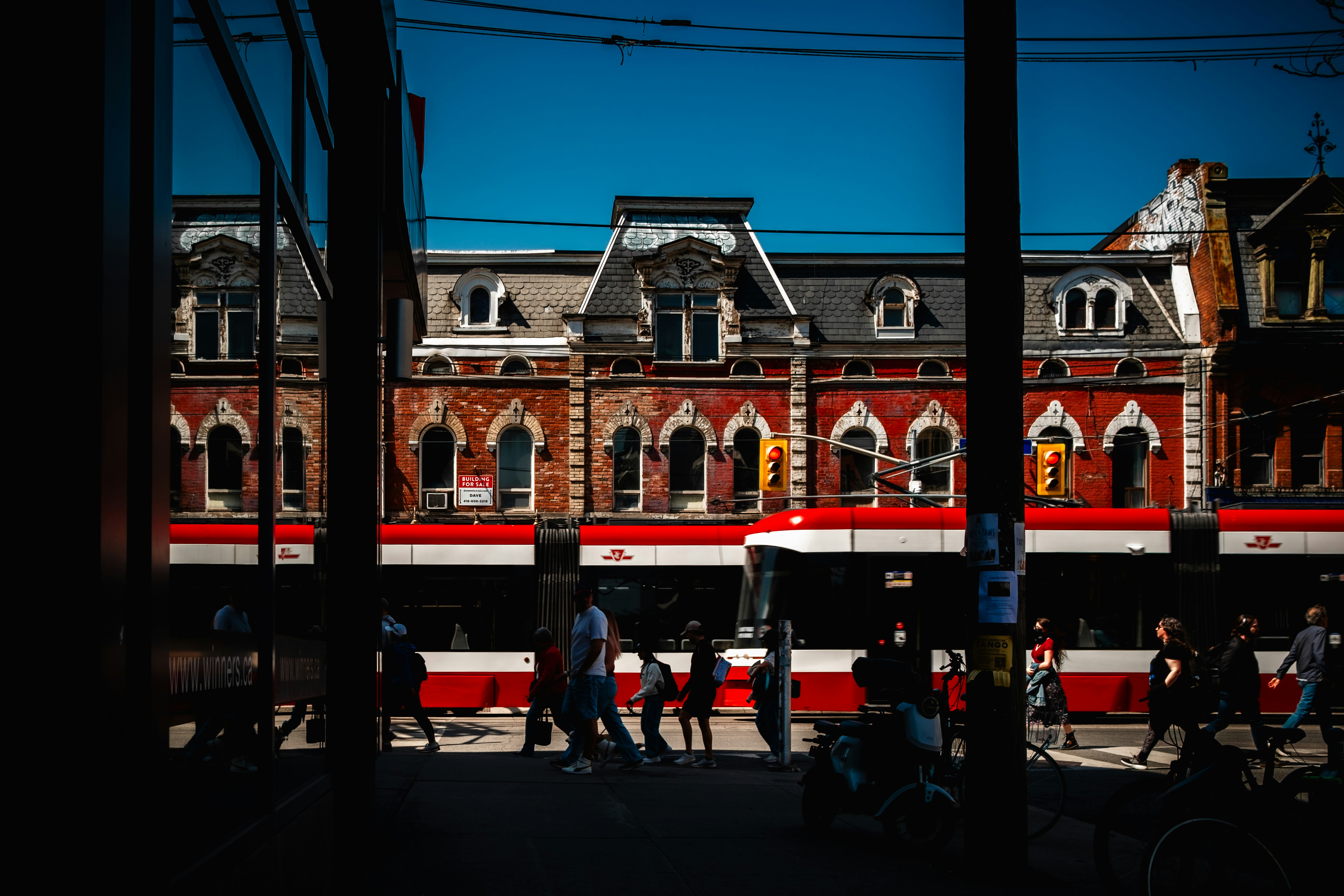 A red streetcar passes historic buildings in toronto.