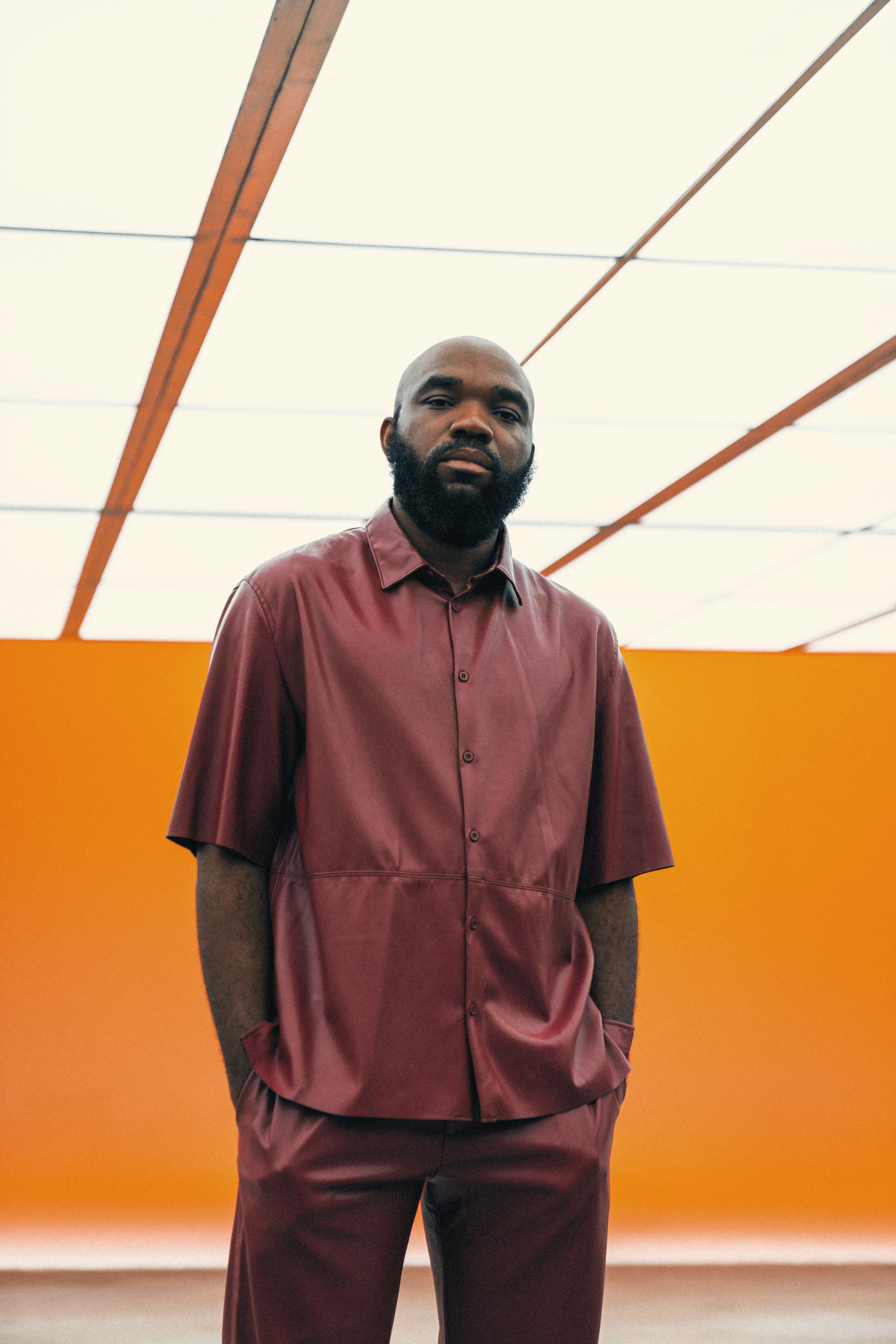 A man poses in a stylish, red outfit.