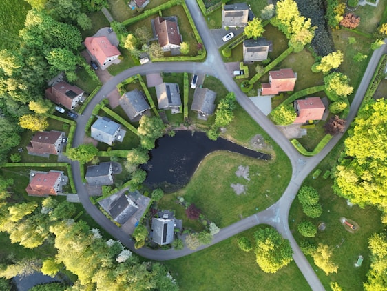Aerial view of a charming neighborhood with a pond.