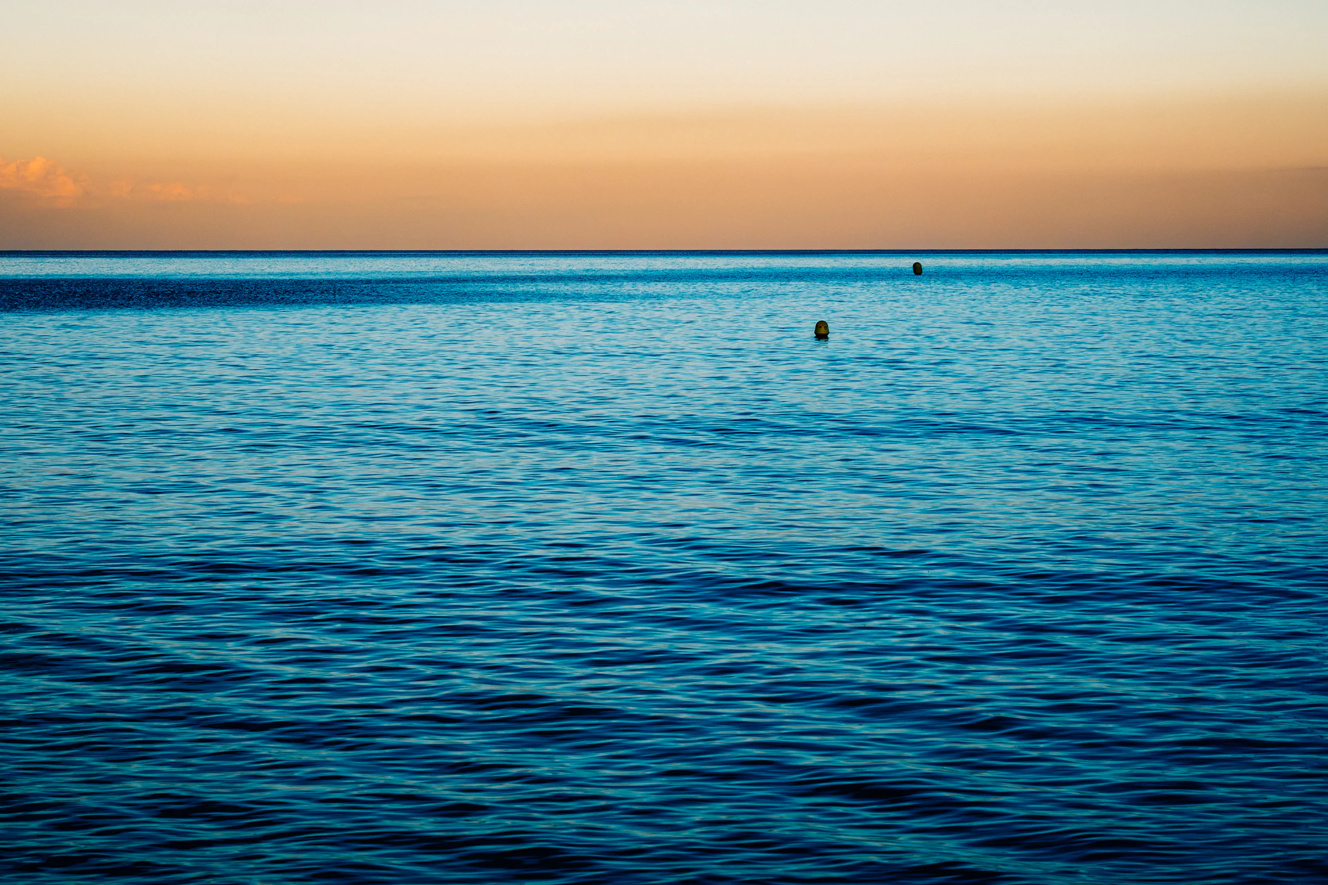 Calm blue sea meeting an orange sky