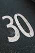 A white "30" is painted on the asphalt.