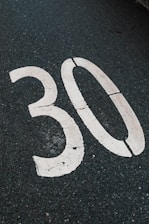 A white "30" is painted on the asphalt.
