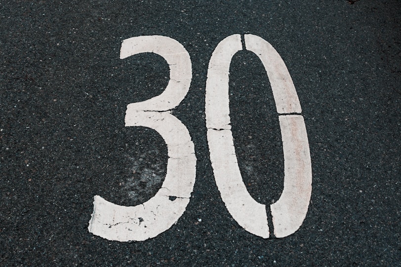 The number thirty is painted on asphalt.