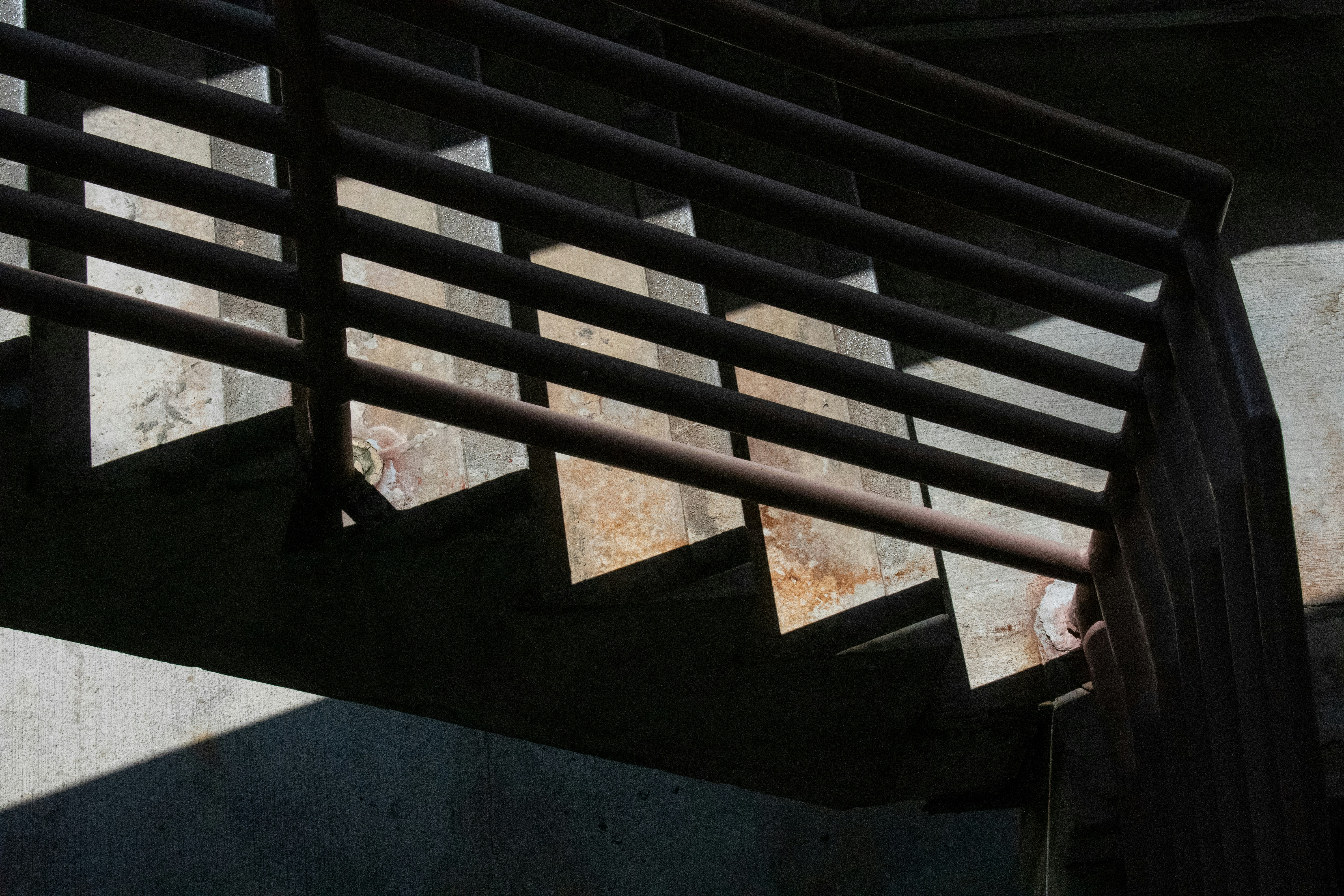 Staircase with metal railing and shadow.