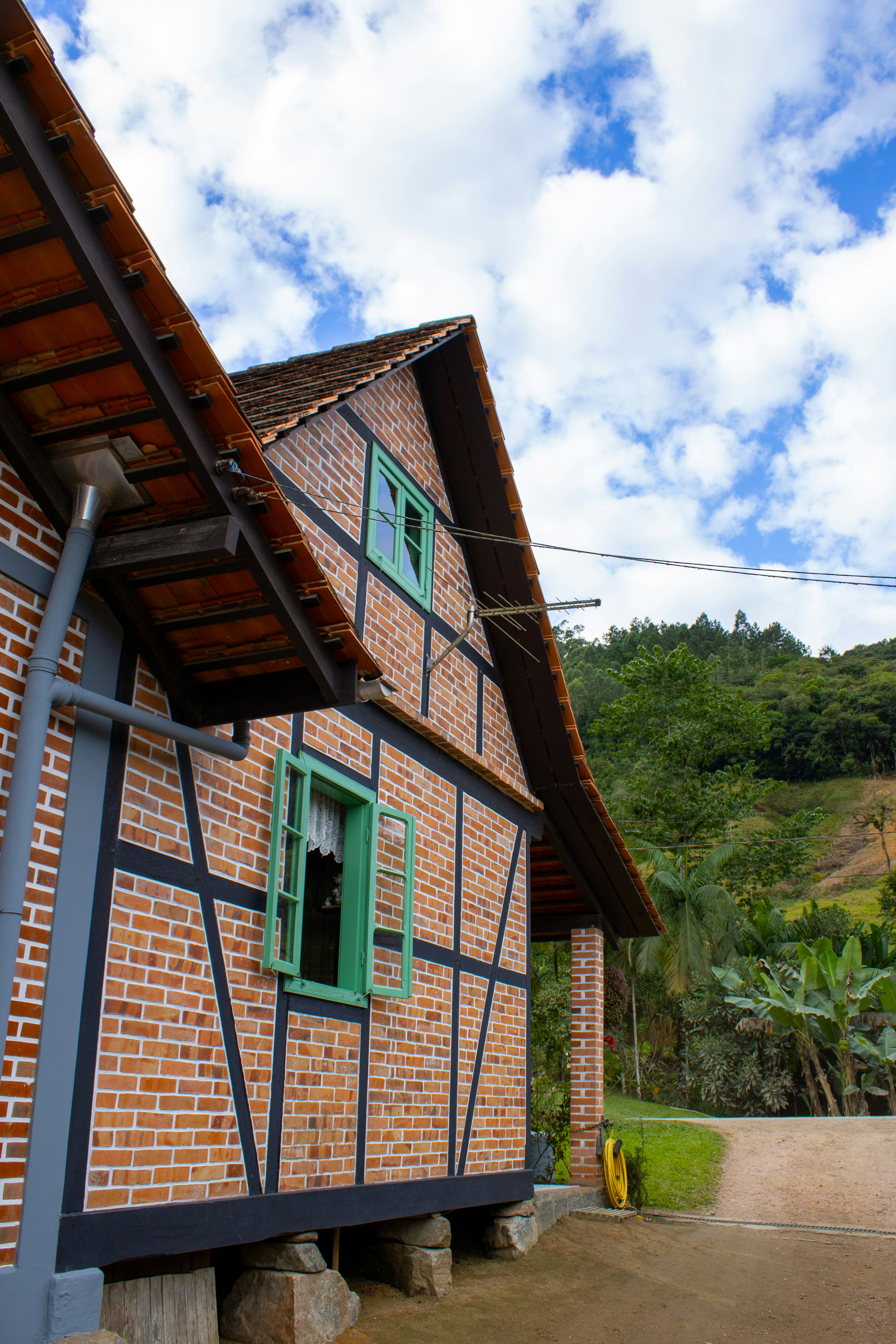 A charming, brick house with green windows.