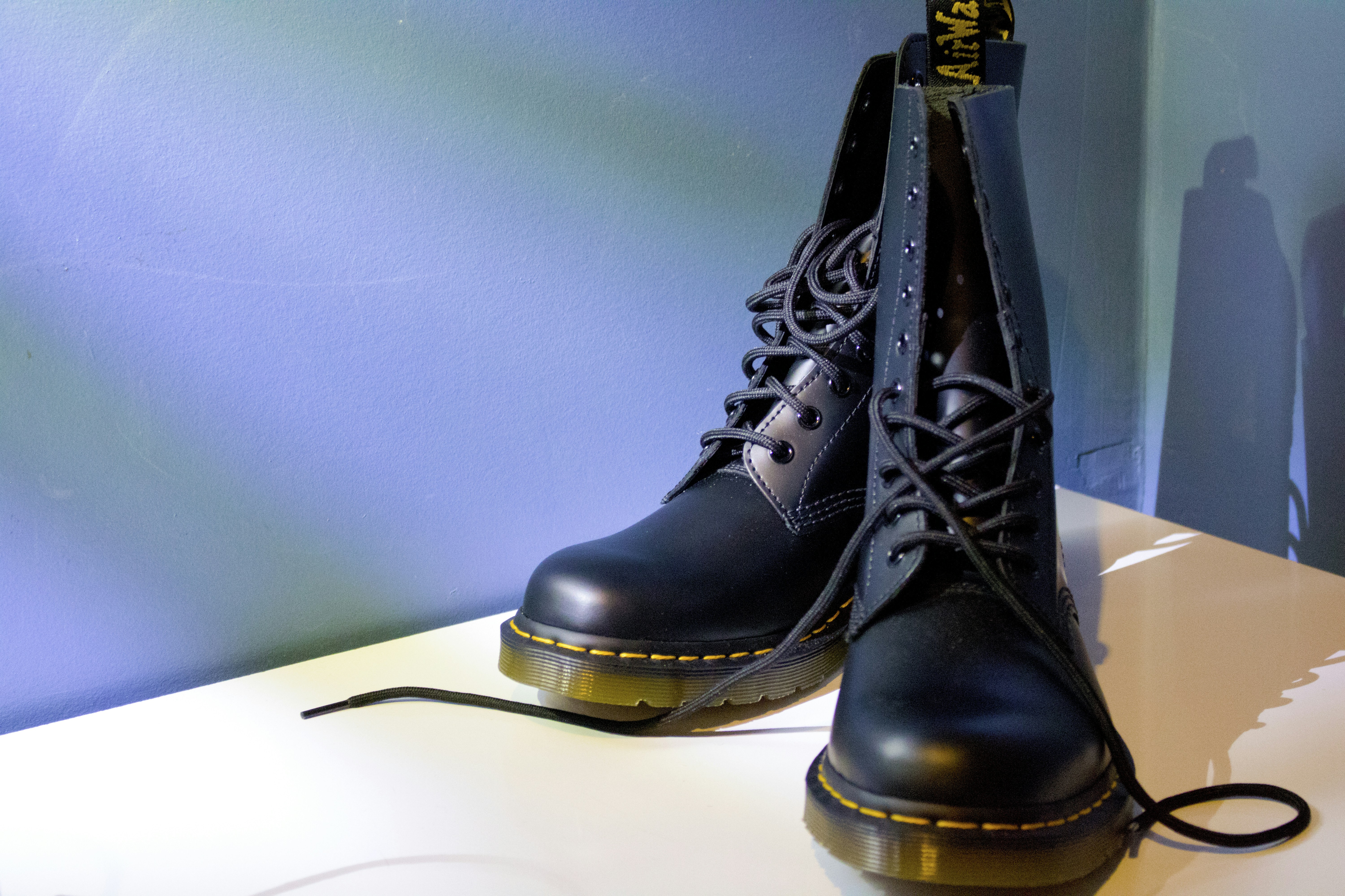 Black dr. martens boots are on a white surface.