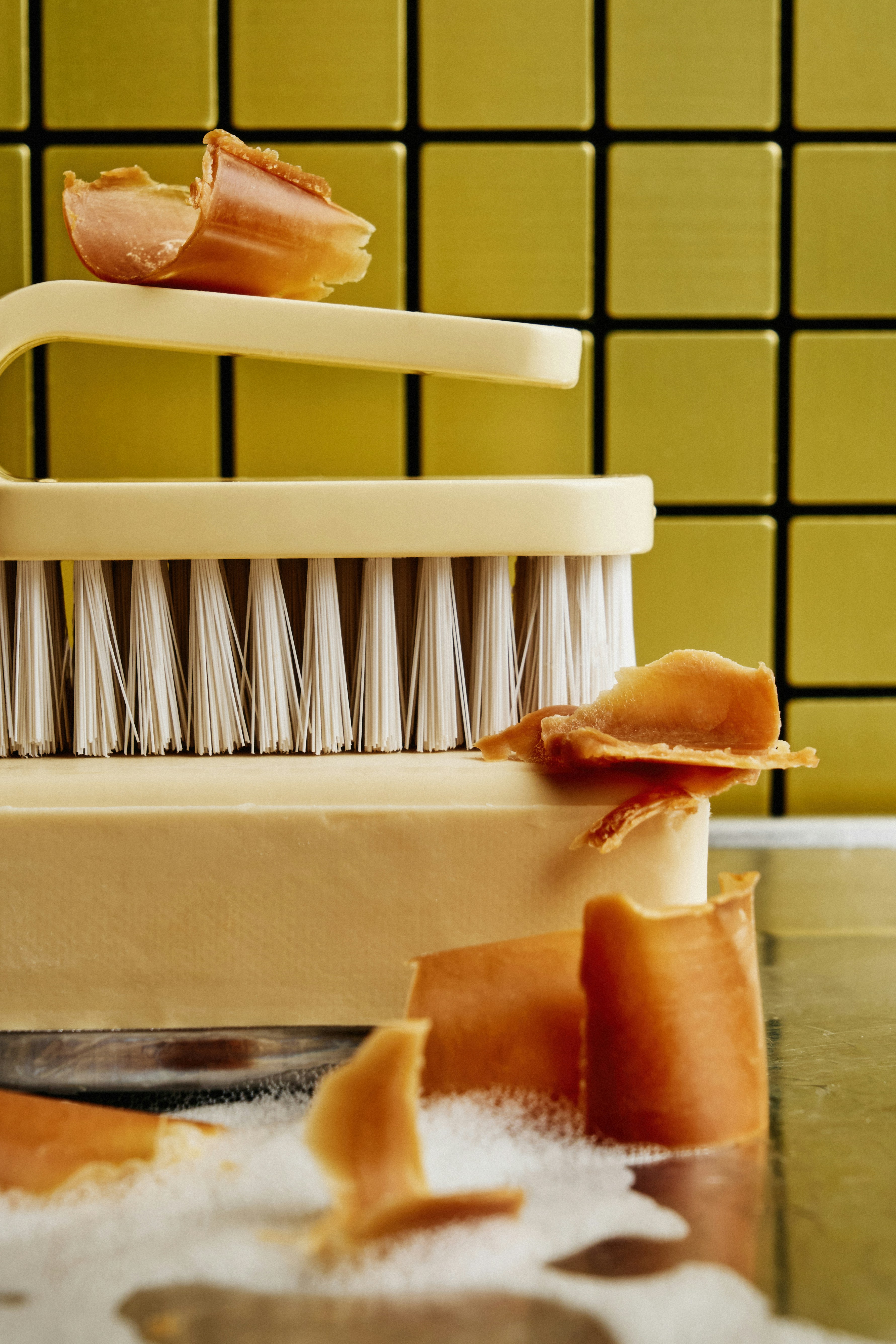 Ensaboe e escove com fragmentos em água com sabão.