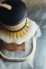 A soap brush is in soapy water.