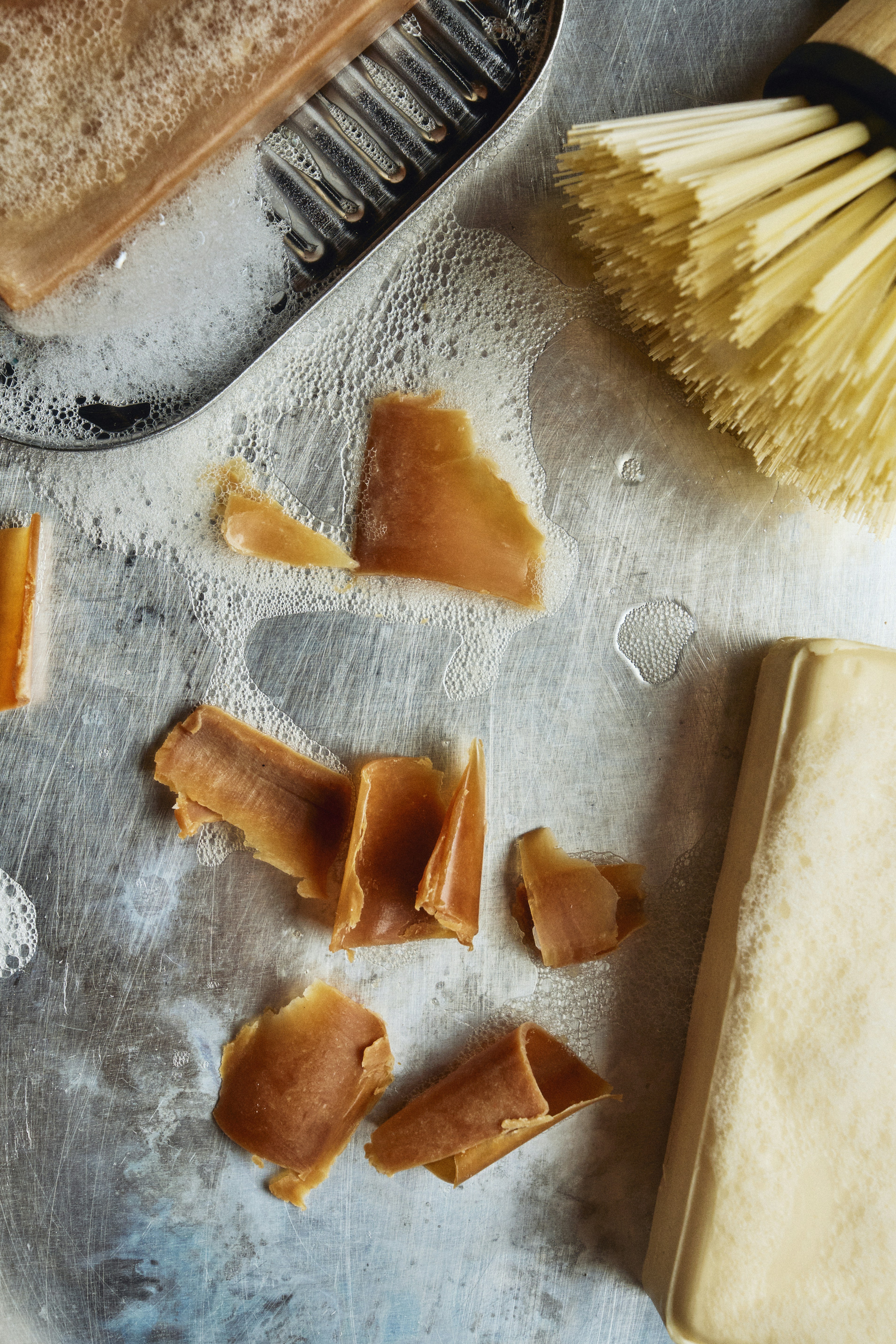 表面に石鹸の削りくず、泡、ブラシ、石鹸。