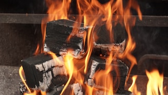 Burning charcoal and flames are visible.