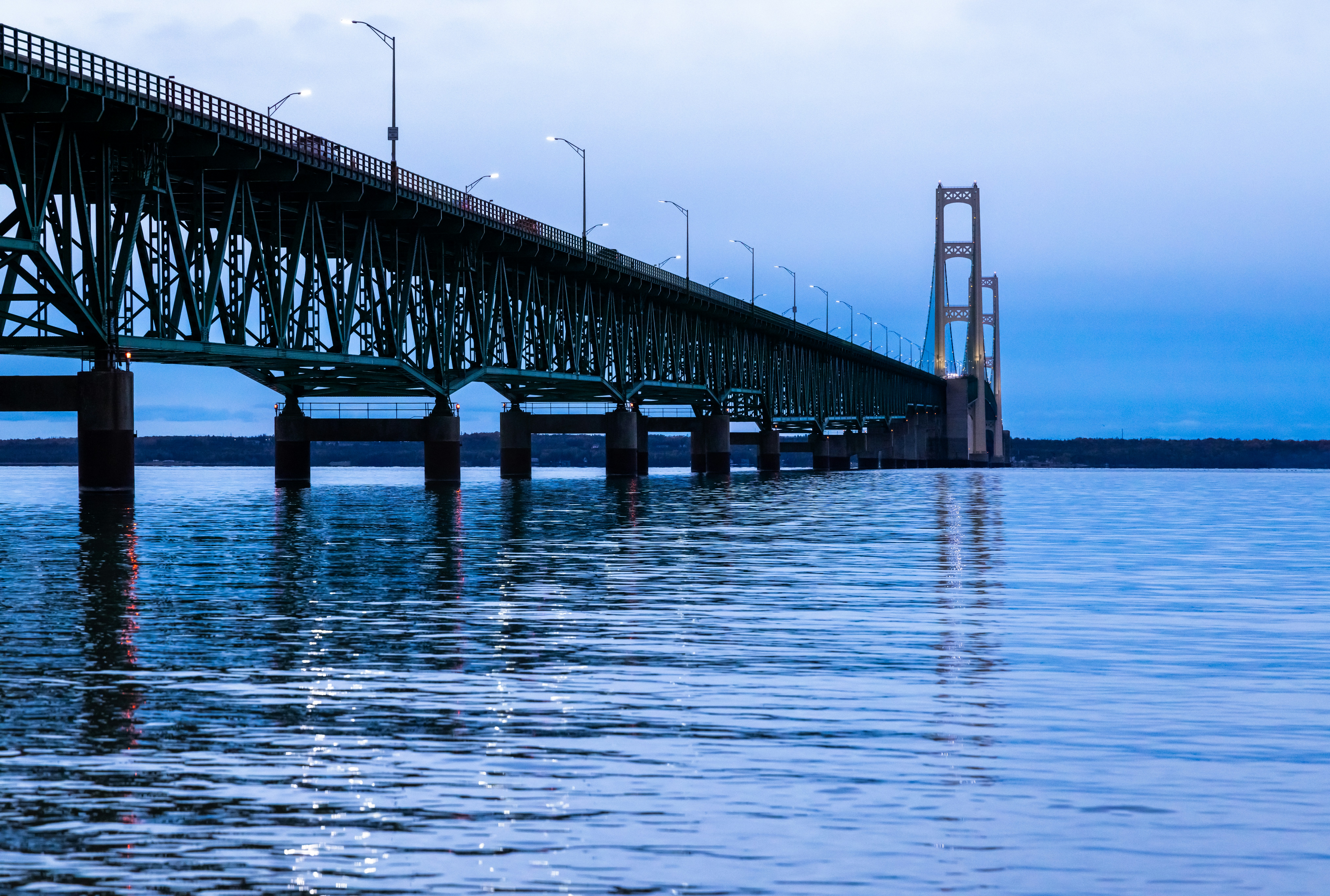 A large bridge spans across calm, blue water.