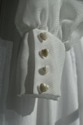 Sleeve cuff with heart-shaped buttons.