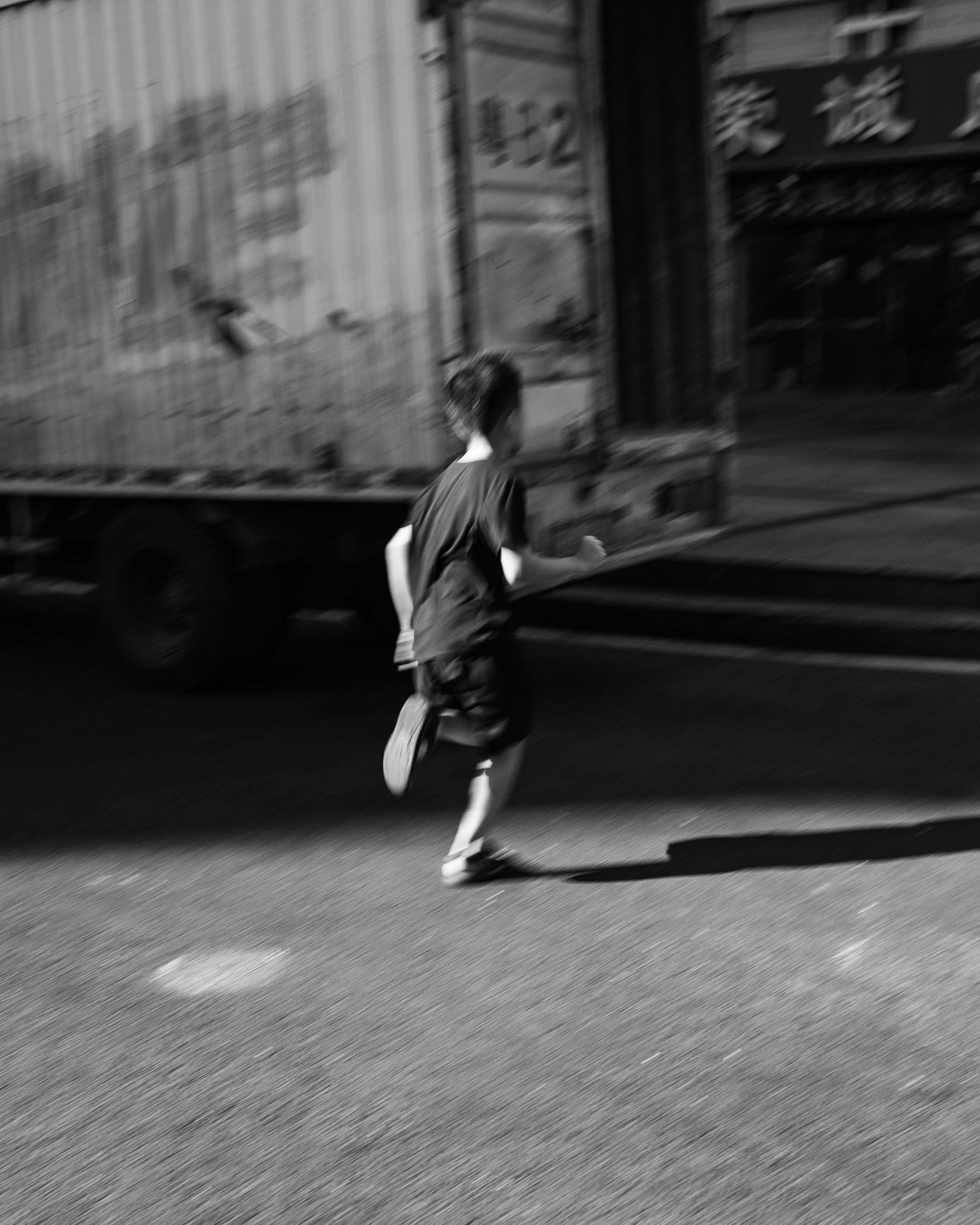 A child runs past a blurry truck.