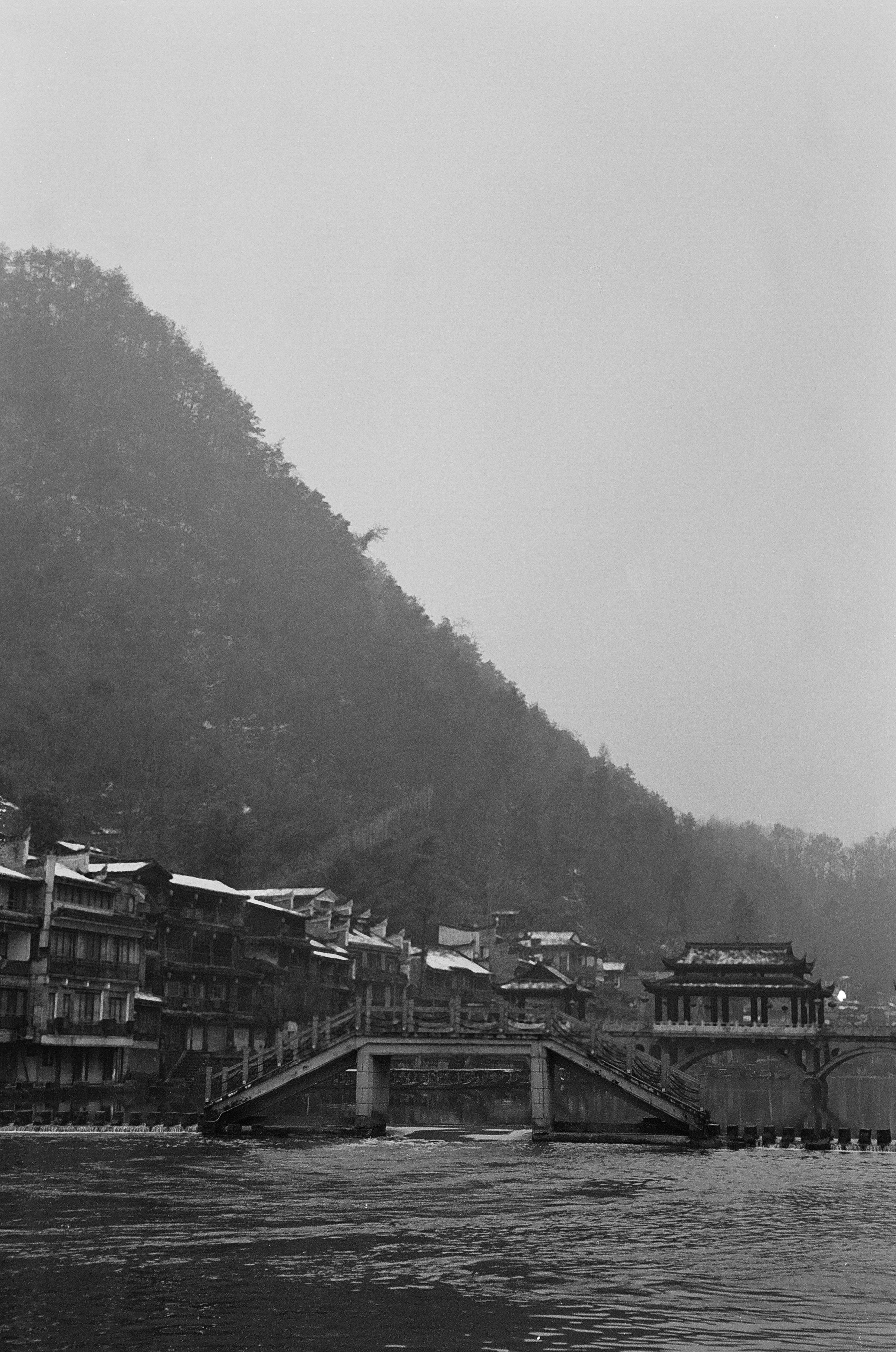 A bridge spans over water with houses.