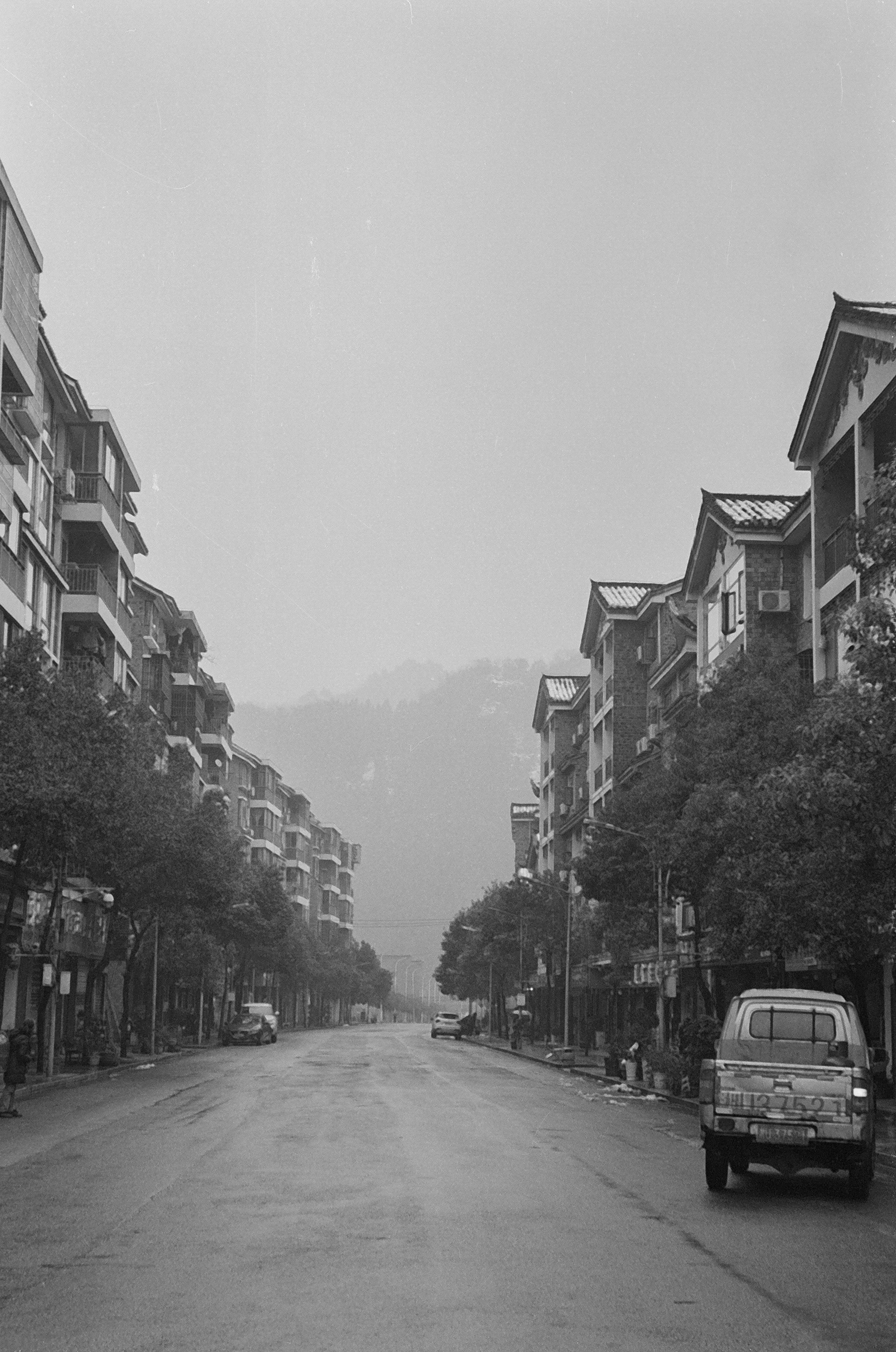 Quiet, empty street in a grayscale photograph.