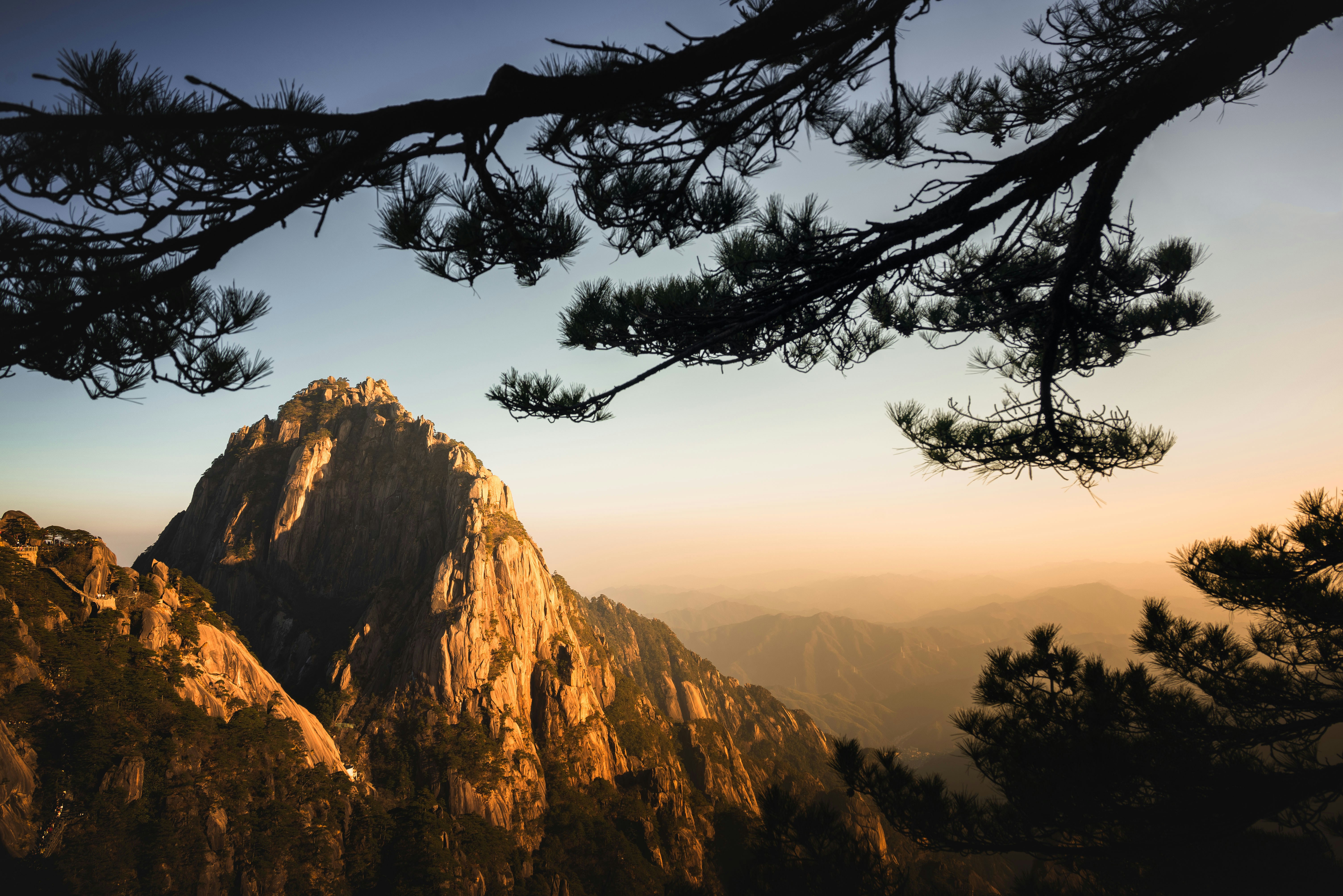 A mountain peak is illuminated by golden sunlight.
