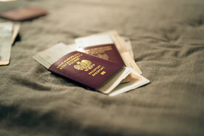 Passports are resting on a textured, neutral surface.