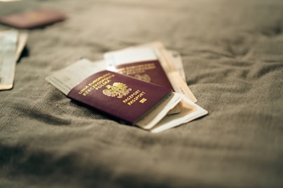 Passports are resting on a textured, neutral surface.