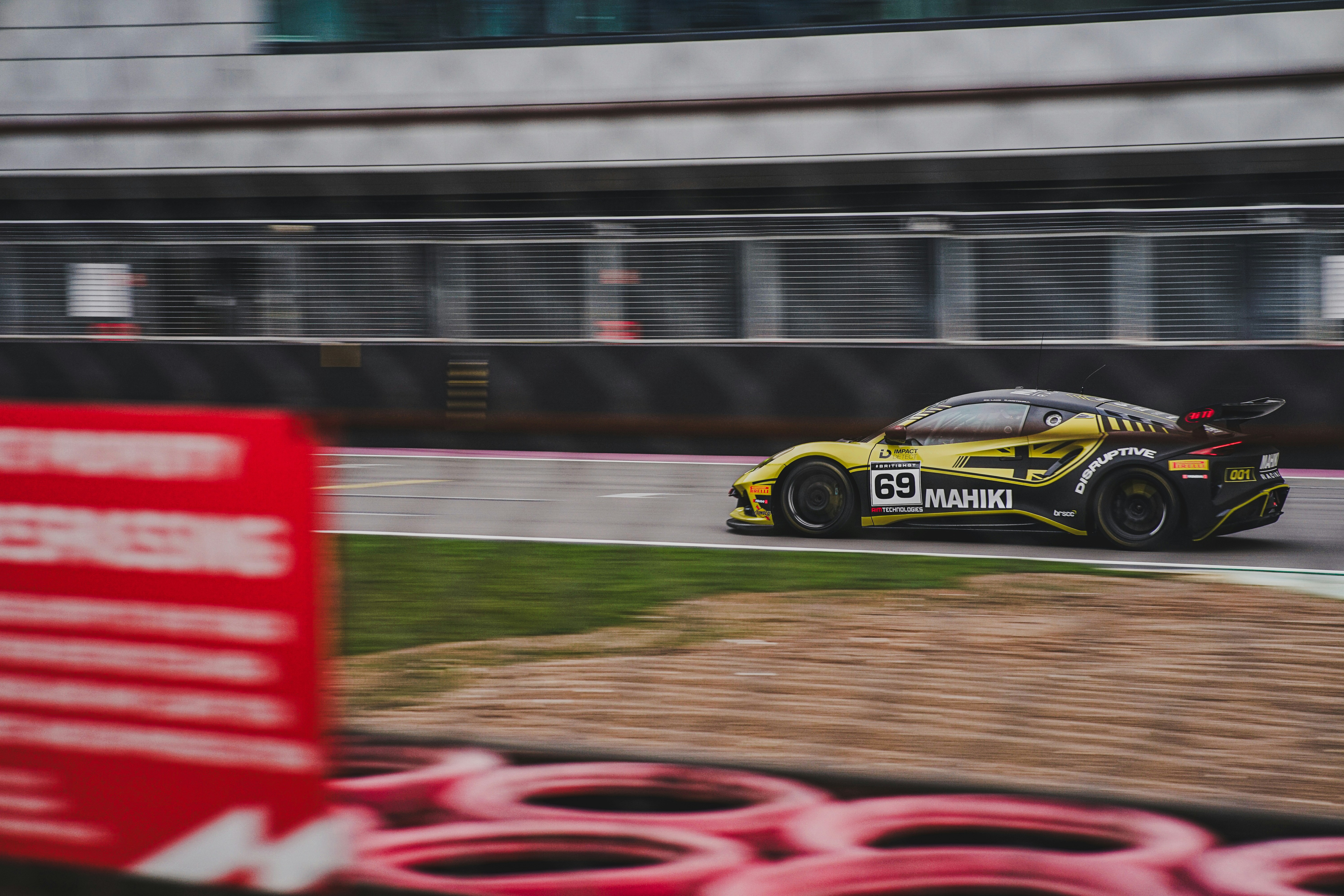 A yellow race car speeds around the track.